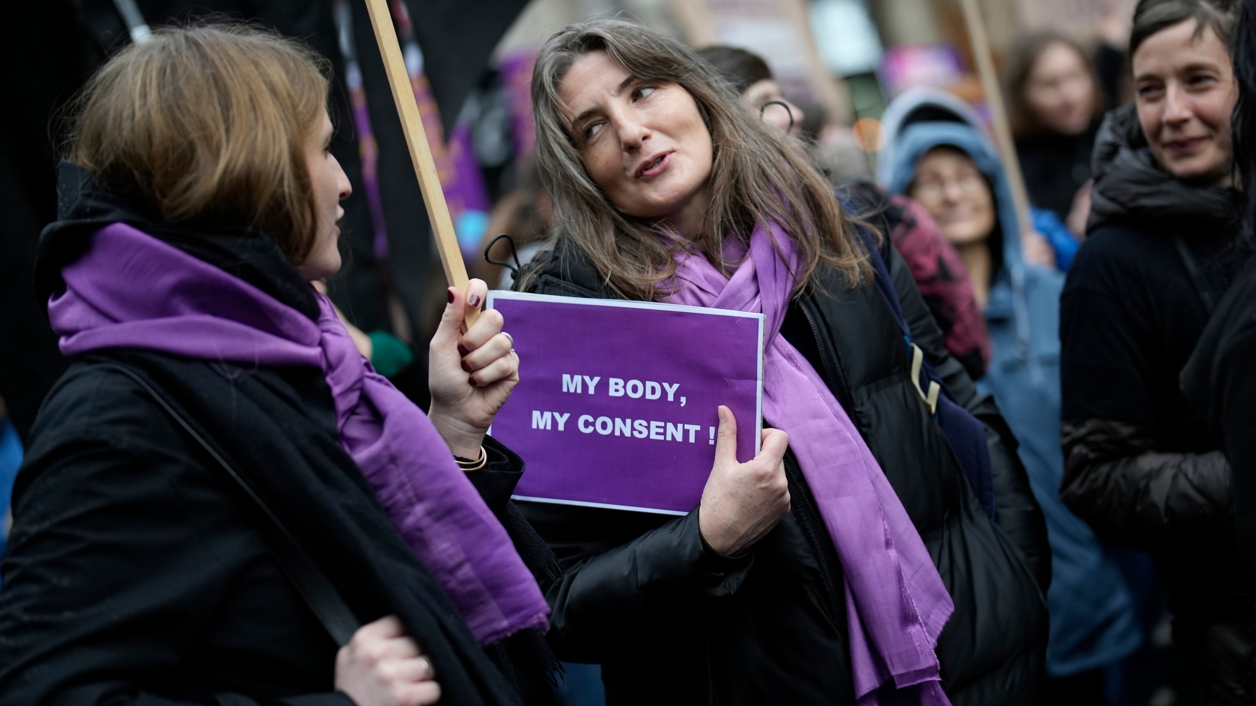 FILE - Women talk during a demonstration as part of the International Women's Day, March 8, 2023 in Paris. Women across the world will demand equal pay, reproductive rights, education, justice and other essential needs during demonstrations marking International Women’s Day on Friday, March 8, 2024. (AP Photo/Christophe Ena, File)