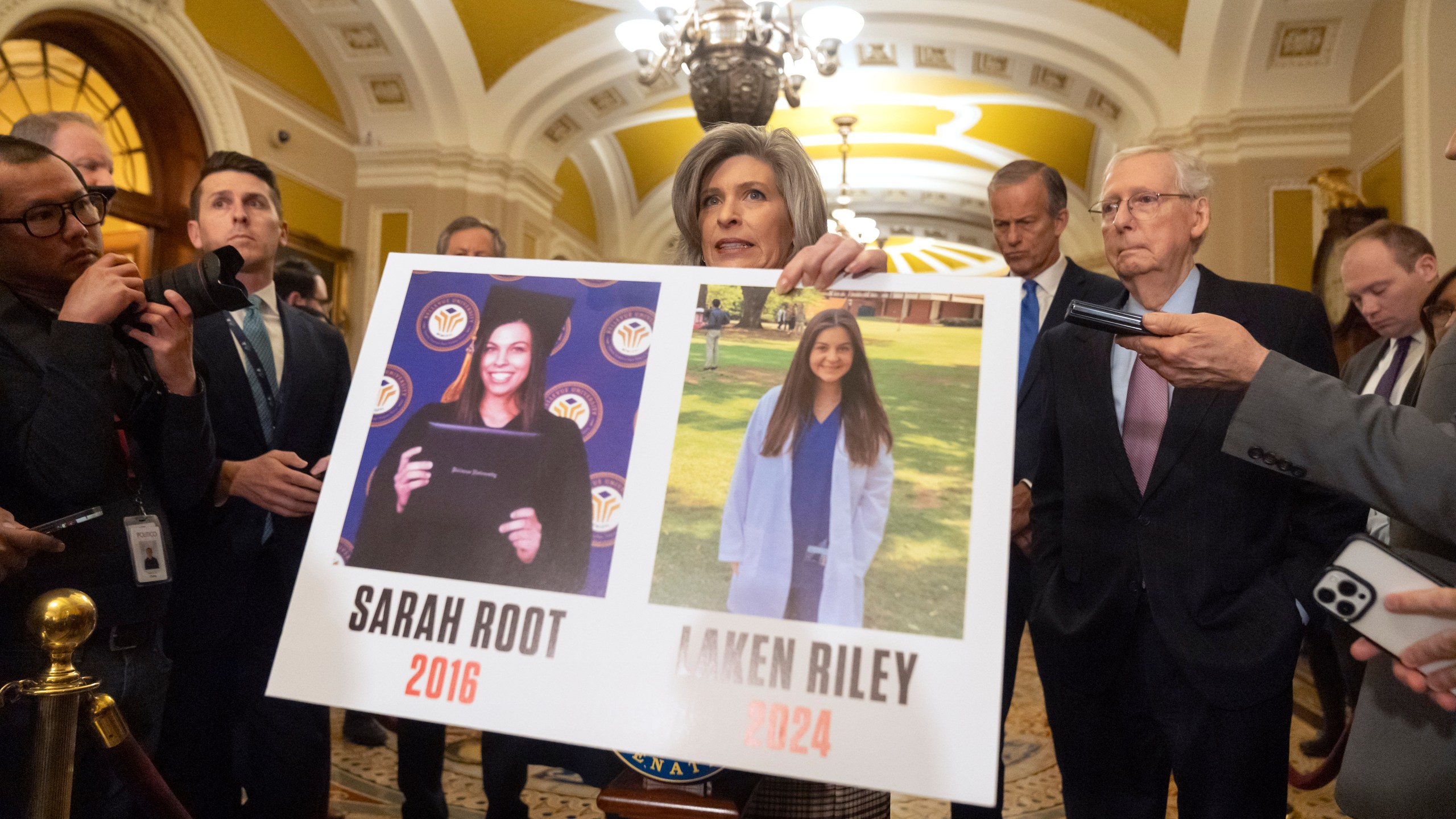 FILE - Sen. Joni Ernst, R-Iowa, holds a poster with photos of murder victims Sarah Root and Laken Riley as she speaks on Capitol Hill, Feb. 27, 2024, in Washington. House Republicans have passed a bill that would require federal authorities to detain unauthorized immigrants who have been accused of theft, seizing on the recent death of Laken, a nursing student in Georgia. The bill sends a rebuke to President Joe Biden’s border policies just hours ahead of his State of the Union address. However, the nine-page bill had little chance of being taken up in the Democratic-controlled Senate. (AP Photo/Mark Schiefelbein, File)