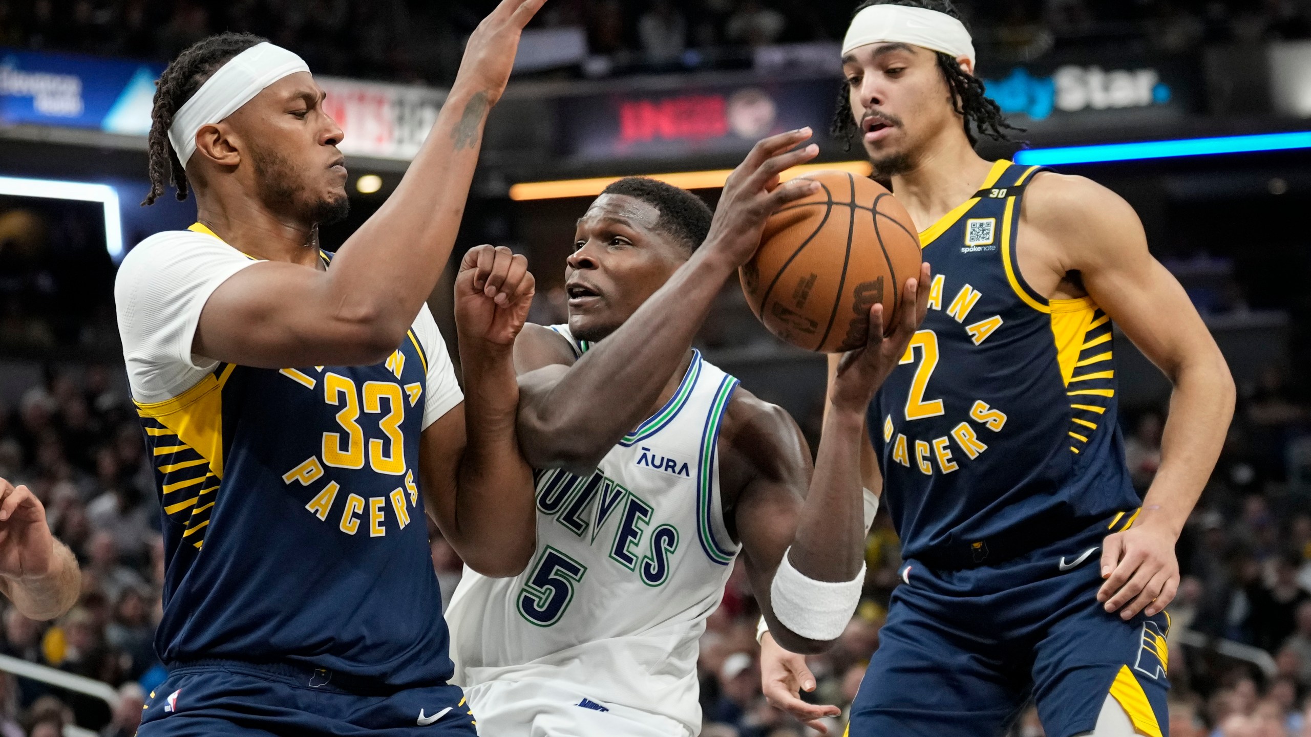 Minnesota Timberwolves guard Anthony Edwards (5) works between Indiana Pacers defenders Myles Turner, left, and Andrew Nembhard during the second half of an NBA basketball game Thursday, March 7, 2024, in Indianapolis. The Timberwolves won 113-111. (AP Photo/AJ Mast)