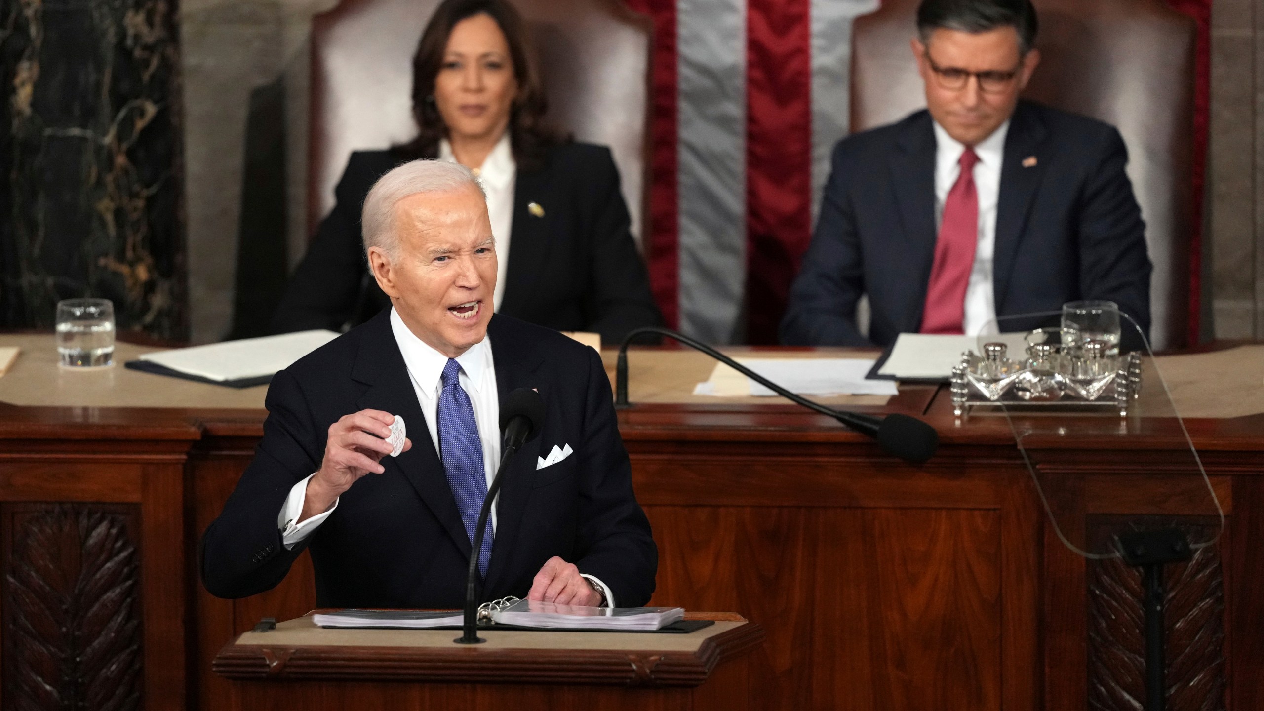 President Joe Biden holds a Laken Riley Botton as delivers the State of the Union address to a joint session of Congress at the U.S. Capitol, Thursday March 7, 2024, in Washington, while Vice President Kamala Harris and House Speaker Mike Johnson of La., watch. (AP Photo/Andrew Harnik)