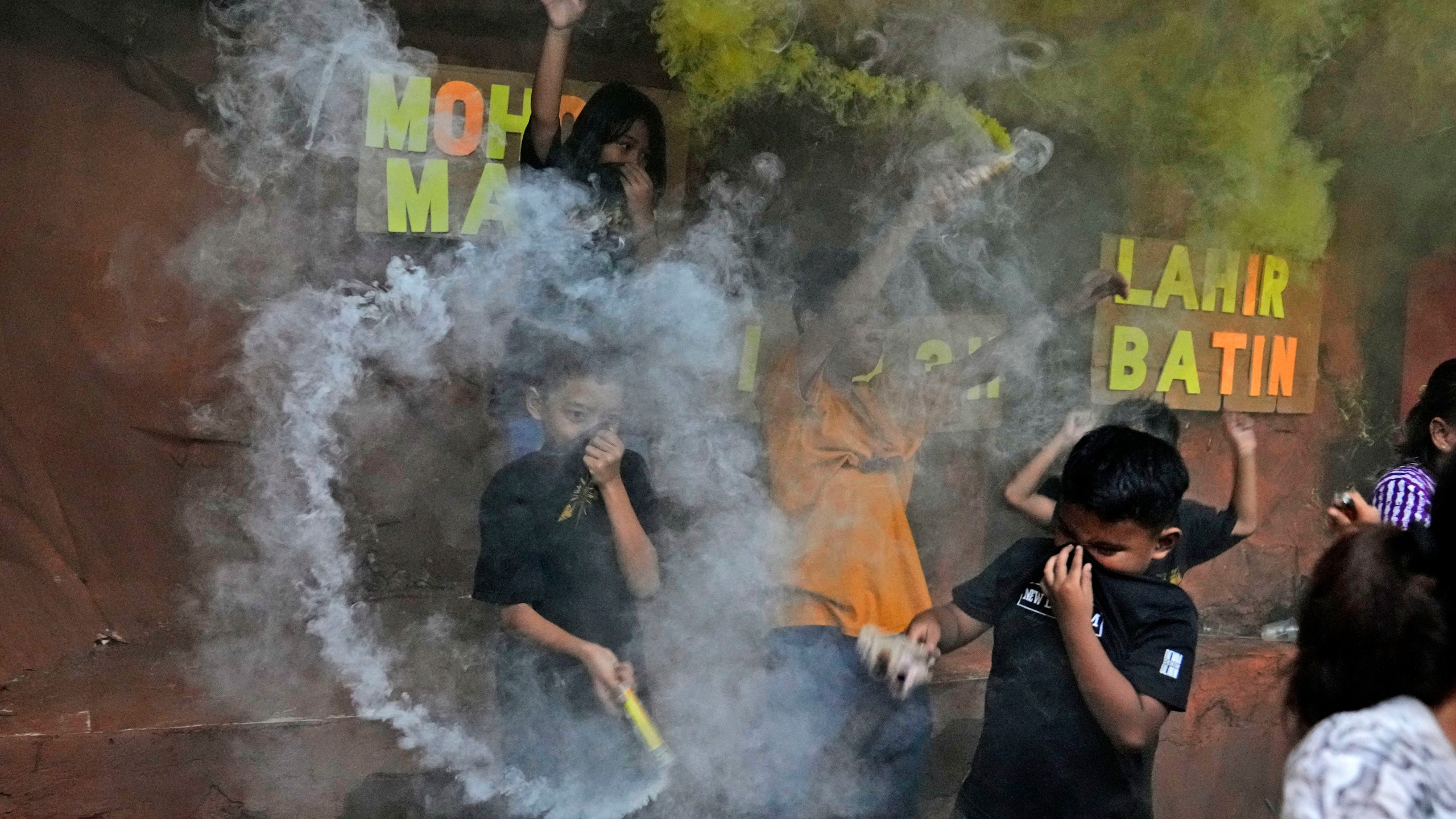 FILE - Boys light smoke bombs as they celebrate the eve of Eid al-Fitr, the holiday marking the end of the holy fasting month of Ramadan, in Jakarta, Indonesia, Sunday, May 1, 2022. (AP Photo/Dita Alangkara, File)
