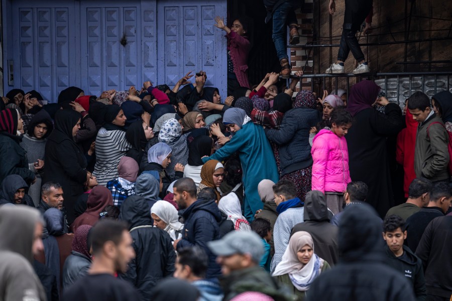 File - Palestinian crowds struggle to buy bread from a bakery in Rafah, Gaza Strip, Sunday, Feb. 18, 2024. (AP Photo/Fatima Shbair, File)