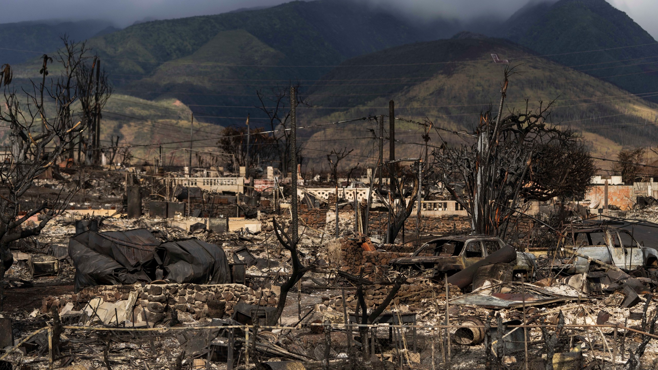 FILE - Damaged property lies scattered in the aftermath of a wildfire in Lahaina, Hawaii, Aug. 21, 2023. Officials on the Hawaiian island of Maui plan to send debris and ash from the August wildfire that destroyed Lahaina town to the island's central landfill. Local officials in Hawaii plan to open an office in April 2024, that will speed up Maui County's notoriously slow processing of building permits to help the town of Lahaina to recover from last year's deadly wildfire. Keanu Lau Hee, the county’s deputy managing director, told a community meeting in Lahaina that a County Expedited Permitting Center will open in April.(AP Photo/Jae C. Hong, File)