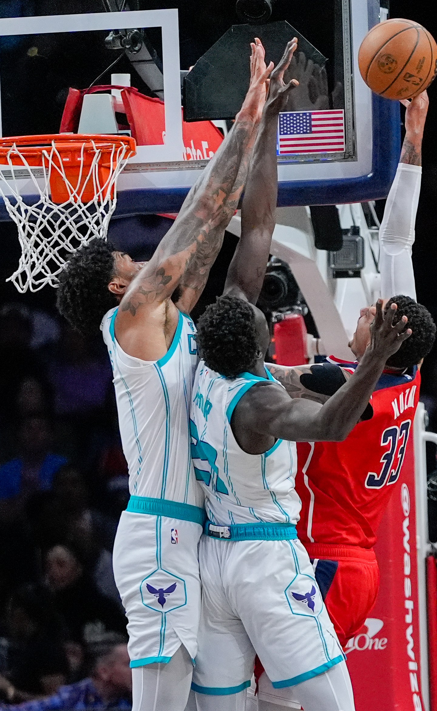 Charlotte Hornets center Nick Richards, left, and forward JT Thor try to block a shot by Washington Wizards forward Kyle Kuzma during the first half of an NBA basketball game Friday, March 8, 2024, in Washington. (AP Photo/Alex Brandon)