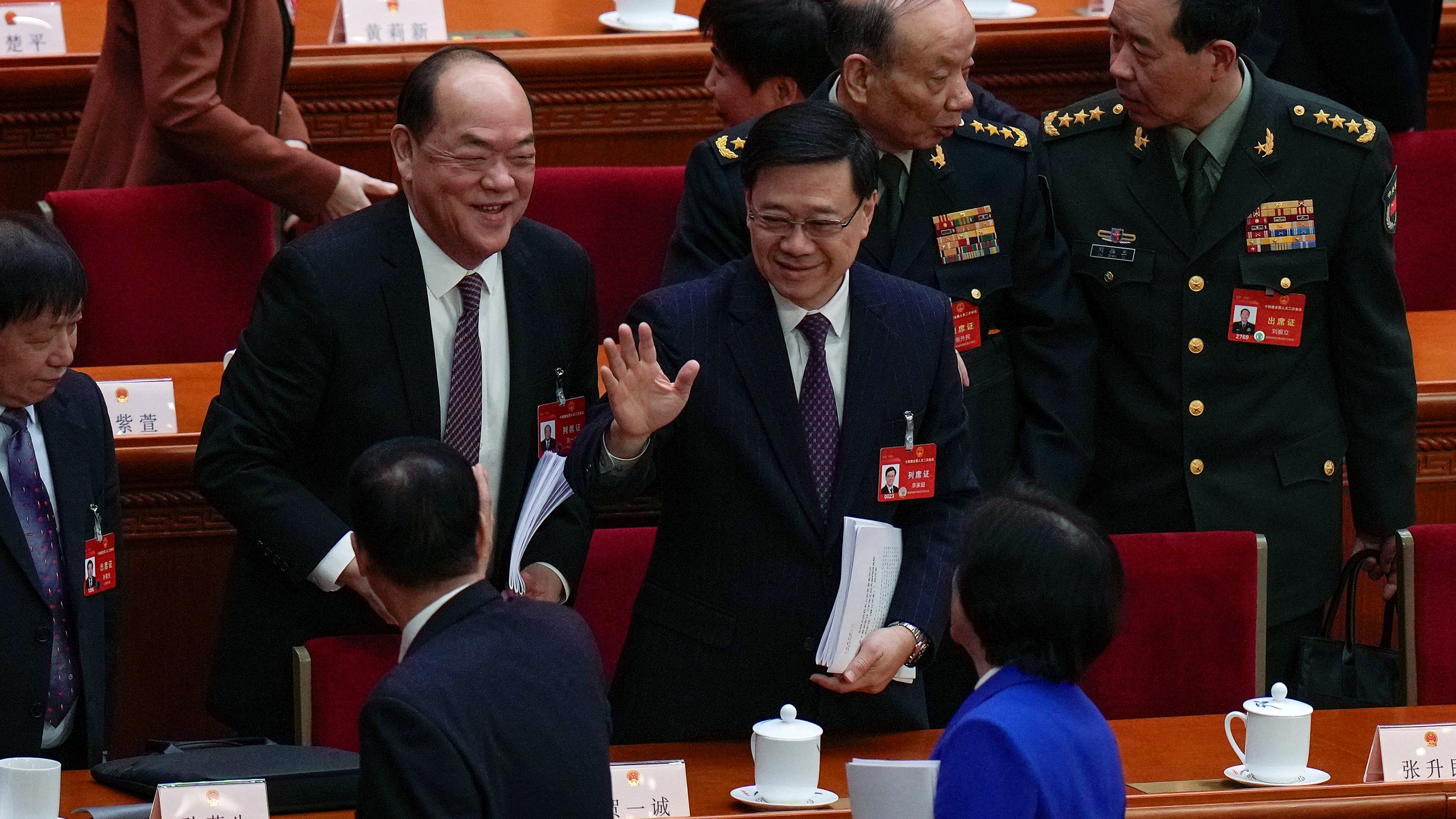 Hong Kong Chief Executive John Lee, center, waves to delegates after the opening session of the National People's Congress (NPC) at the Great Hall of the People in Beijing, Tuesday, March 5, 2024. (AP Photo/Andy Wong)
