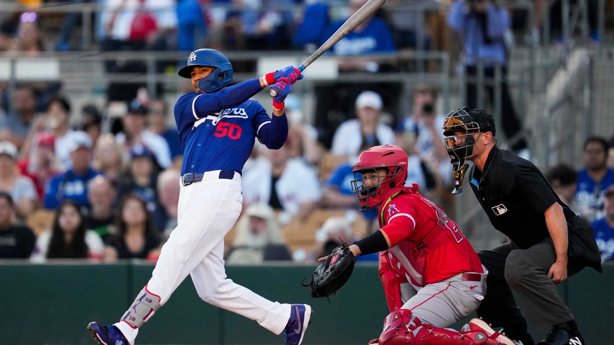 Los Angeles Dodgers' Mookie Betts (50) singles during the first inning of a spring training baseball game against the Los Angeles Angels in Phoenix, Tuesday, March 5, 2024. (AP Photo/Ashley Landis)