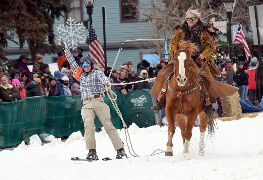 A skijoring team competes in Leadville, Colo., on Saturday, March 2, 2024. Skijoring draws its name from the Norwegian word skikjoring, meaning "ski driving." It started as a practical mode of transportation in Scandinavia and became popular in the Alps around 1900. Today's sport features horses at full gallop towing skiers by rope over jumps and around obstacles as they try to lance suspended hoops with a baton, typically a ski pole that's cut in half. (AP Photo/Thomas Peipert)