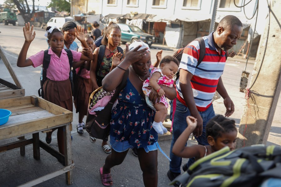 FILE - Residents flee their homes during clashes between police and gang member at the Portail neighborhood in Port-au-Prince, Haiti, Thursday, Feb. 29, 2024. Unrelenting gang attacks in Haiti have paralyzed the country and left it with dwindling supplies of basic goods. Worsening the situation is this week's closure of Port-au-Prince's main seaport. The move left stranded scores of containers filled with critical items like food and medical supplies in a country where U.N. officials say half the population does not have enough to eat and 1.4 million are starving. (AP Photo/Odelyn Joseph, File)