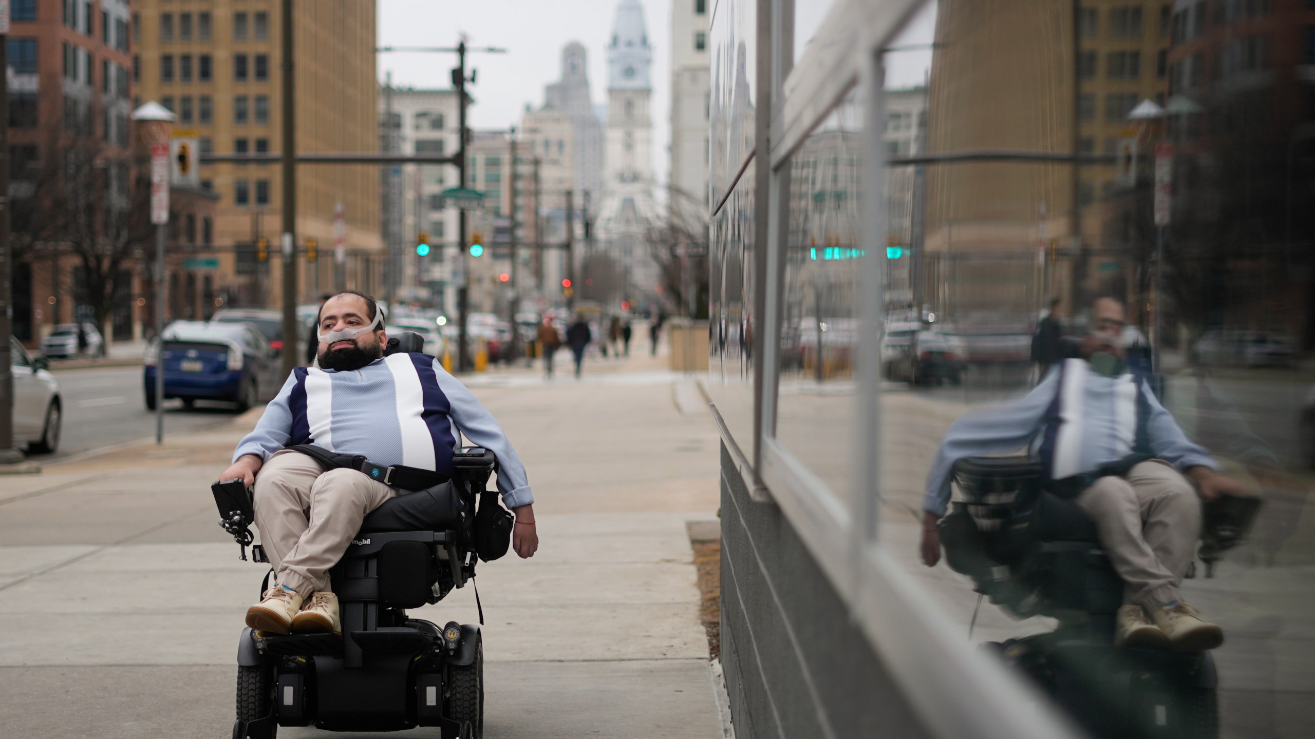 Temple University doctoral student Jaggar DeMarco poses for a portrait while utilizing a battery powered ventilator in Philadelphia, Wednesday, March 6, 2024. “I’m constantly angry that my life and what I can do with (it) is sometimes determined by insurance companies and bureaucracy,” says DeMarco, who has chronic respiratory failure. (AP Photo/Matt Rourke)