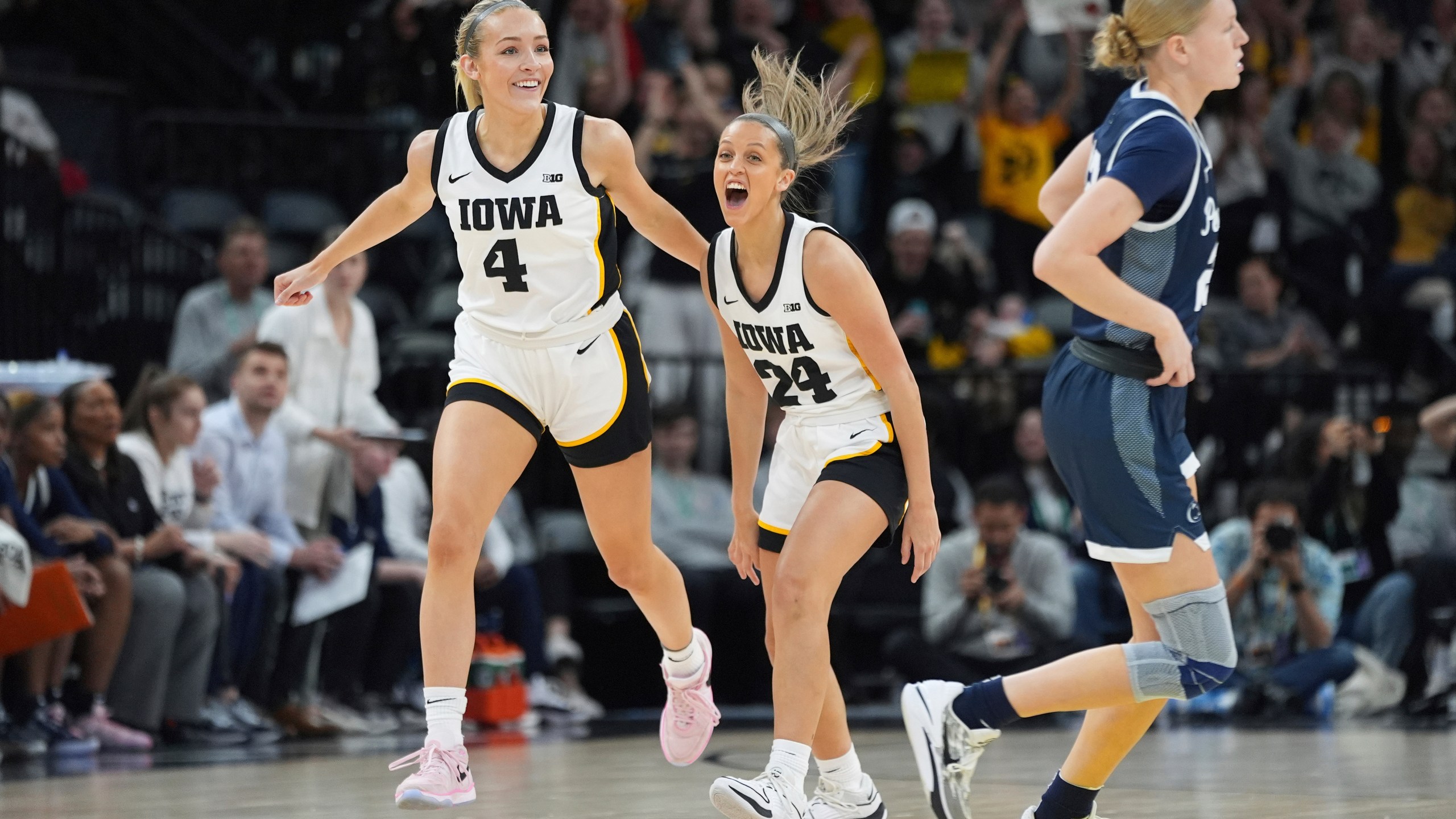 Iowa guard Gabbie Marshall (24) celebrates next to guard Kylie Feuerbach (4) after making a 3-point basket during the first half of an NCAA college basketball quarterfinal game against Penn State at the Big Ten women's tournament Friday, March 8, 2024, in Minneapolis. (AP Photo/Abbie Parr)