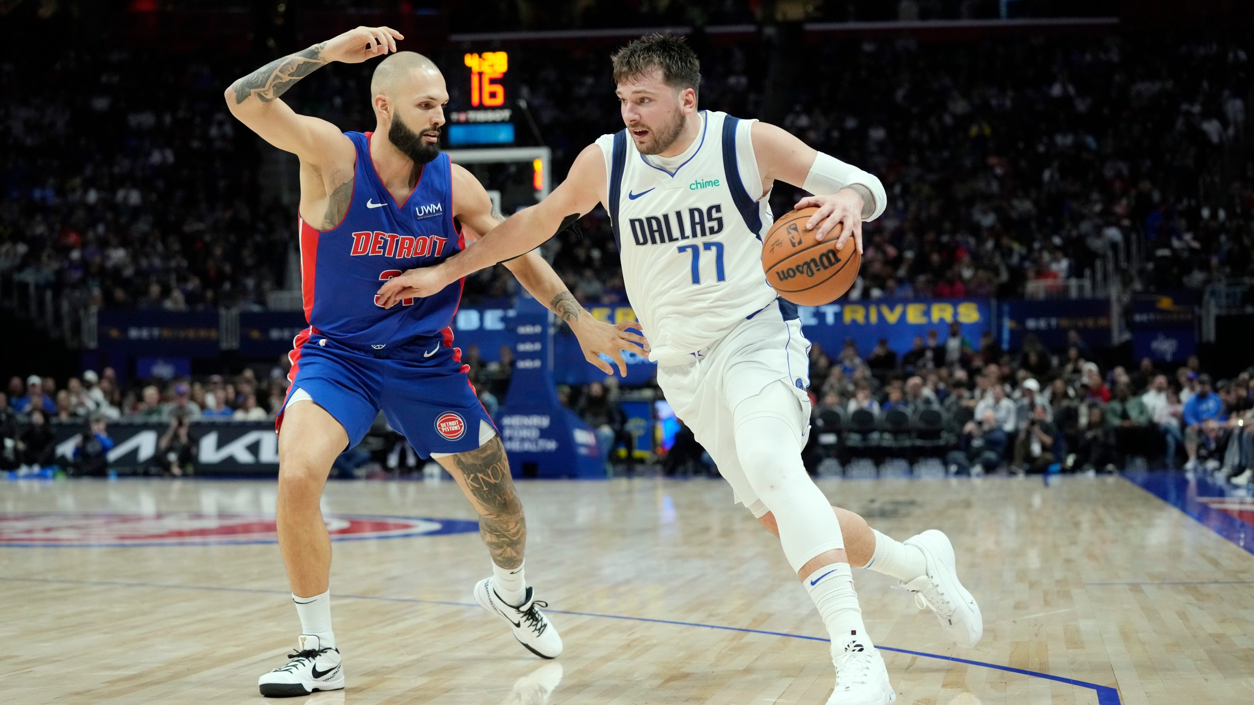 Dallas Mavericks guard Luka Doncic (77) is defended by Detroit Pistons guard Evan Fournier during the second half of an NBA basketball game, Saturday, March 9, 2024, in Detroit. (AP Photo/Carlos Osorio)