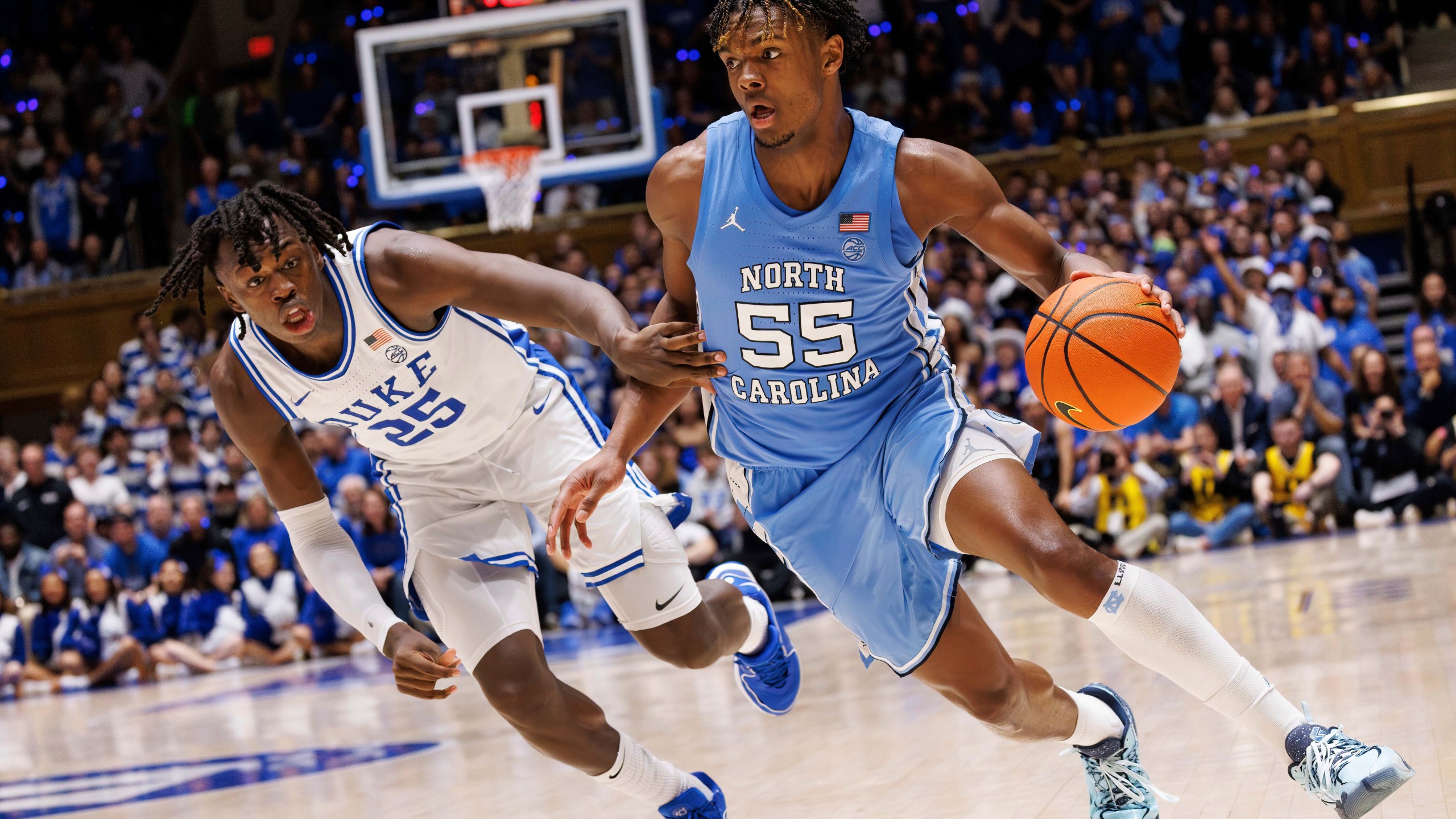 North Carolina's Harrison Ingram (55) handles the ball as Duke's Mark Mitchell (25) defends during the first half of an NCAA college basketball game in Durham, N.C., Saturday, March. 9, 2024. (AP Photo/Ben McKeown)