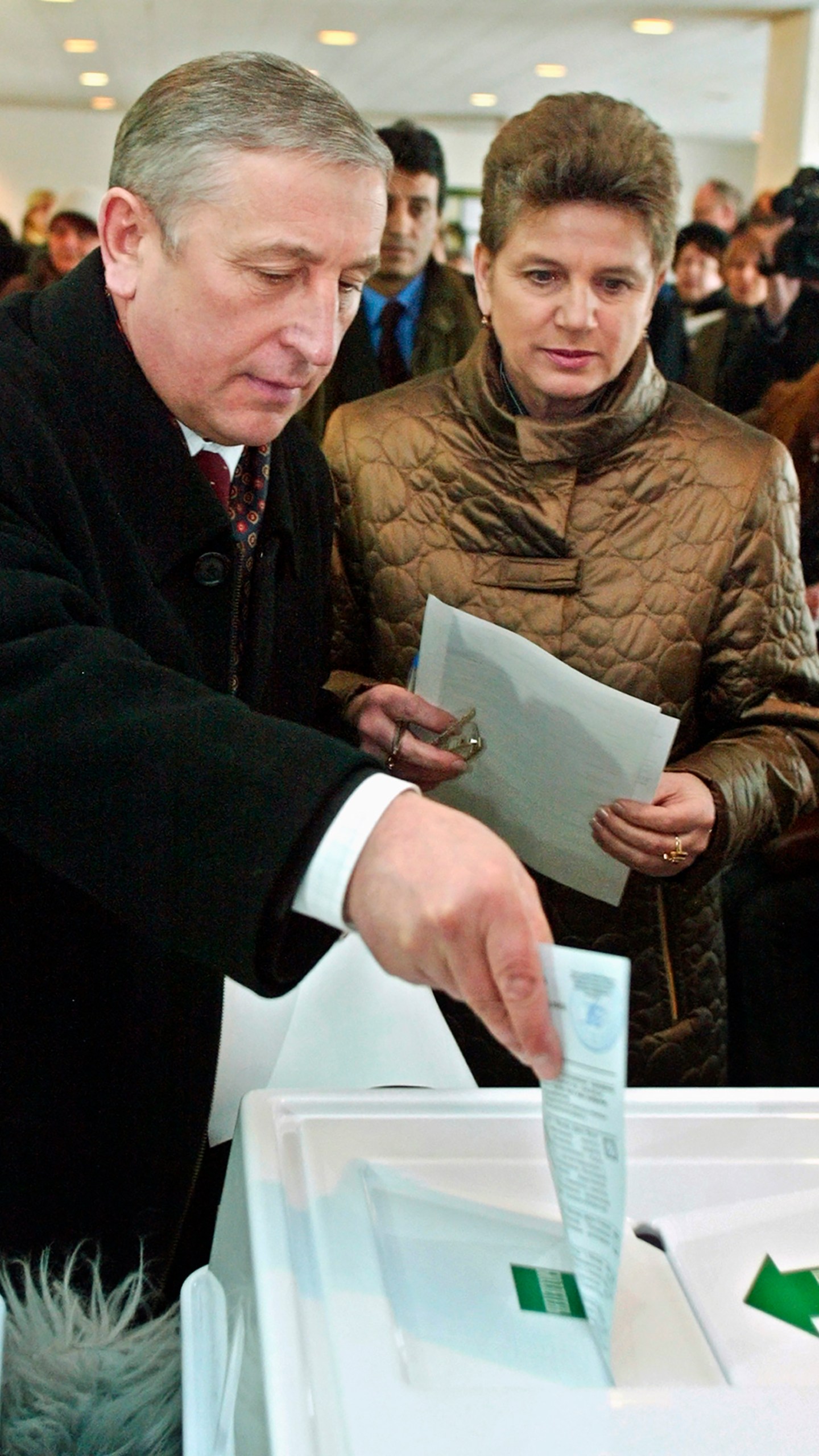 FILE - Russian Communist presidential candidate Nikolai Kharitonov, left, casts his ballot as his wife Nina, right, looks on at a polling station in Moscow, Sunday, March 14, 2004. Kharitonov previously ran against Putin in 2004, finishing a distant second. (AP Photo/Ivan Sekretarev, File)