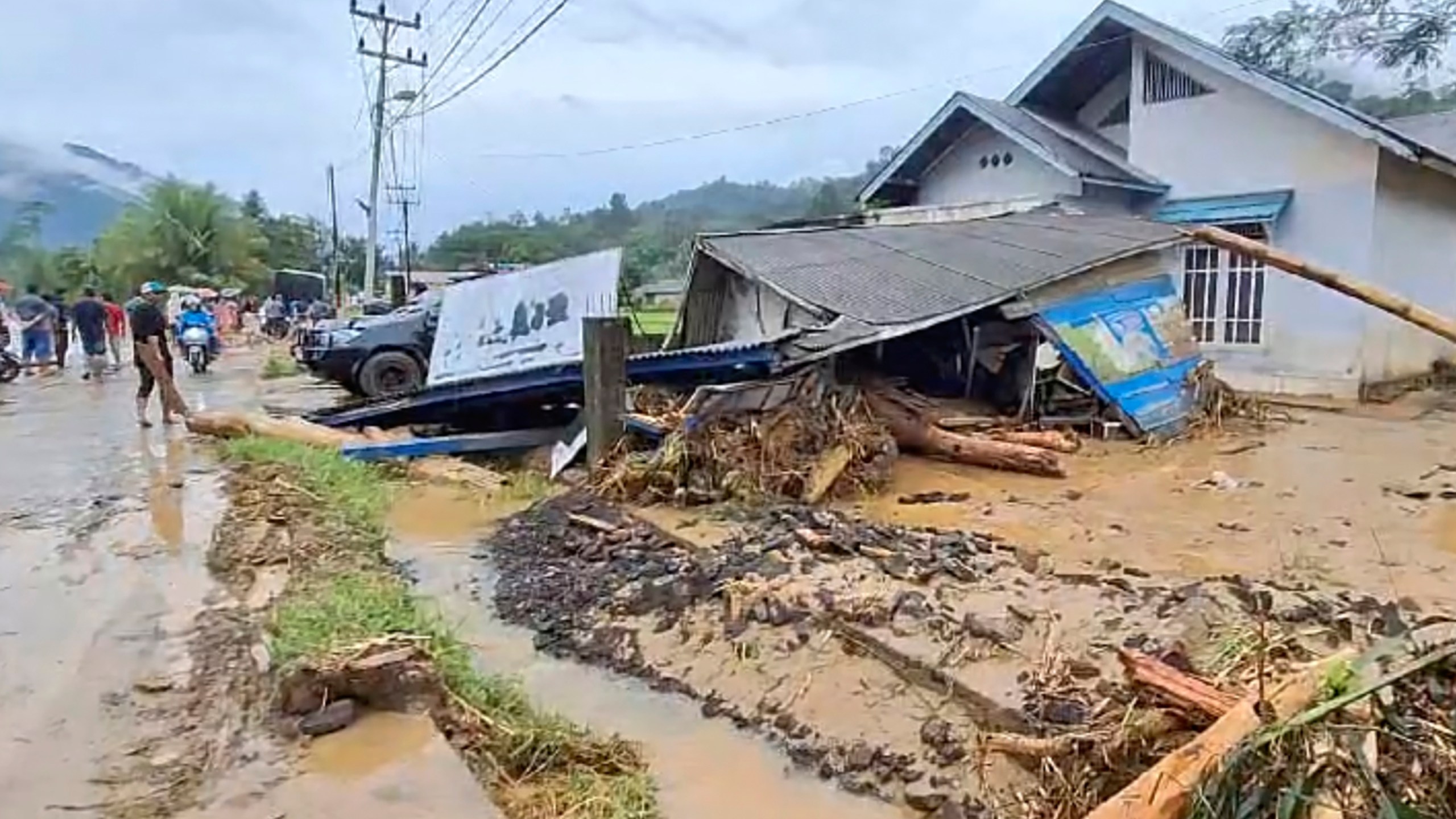 In this image made from video, damaged houses are seen in a village affected by flash flood in Langgai, West Sumatra, Indonesia, Sunday, March 10, 2024. Torrential rains have triggered flash floods and a landslide on Indonesia's Sumatra island leaving a number of people dead and missing, officials said Sunday. (AP Photo)