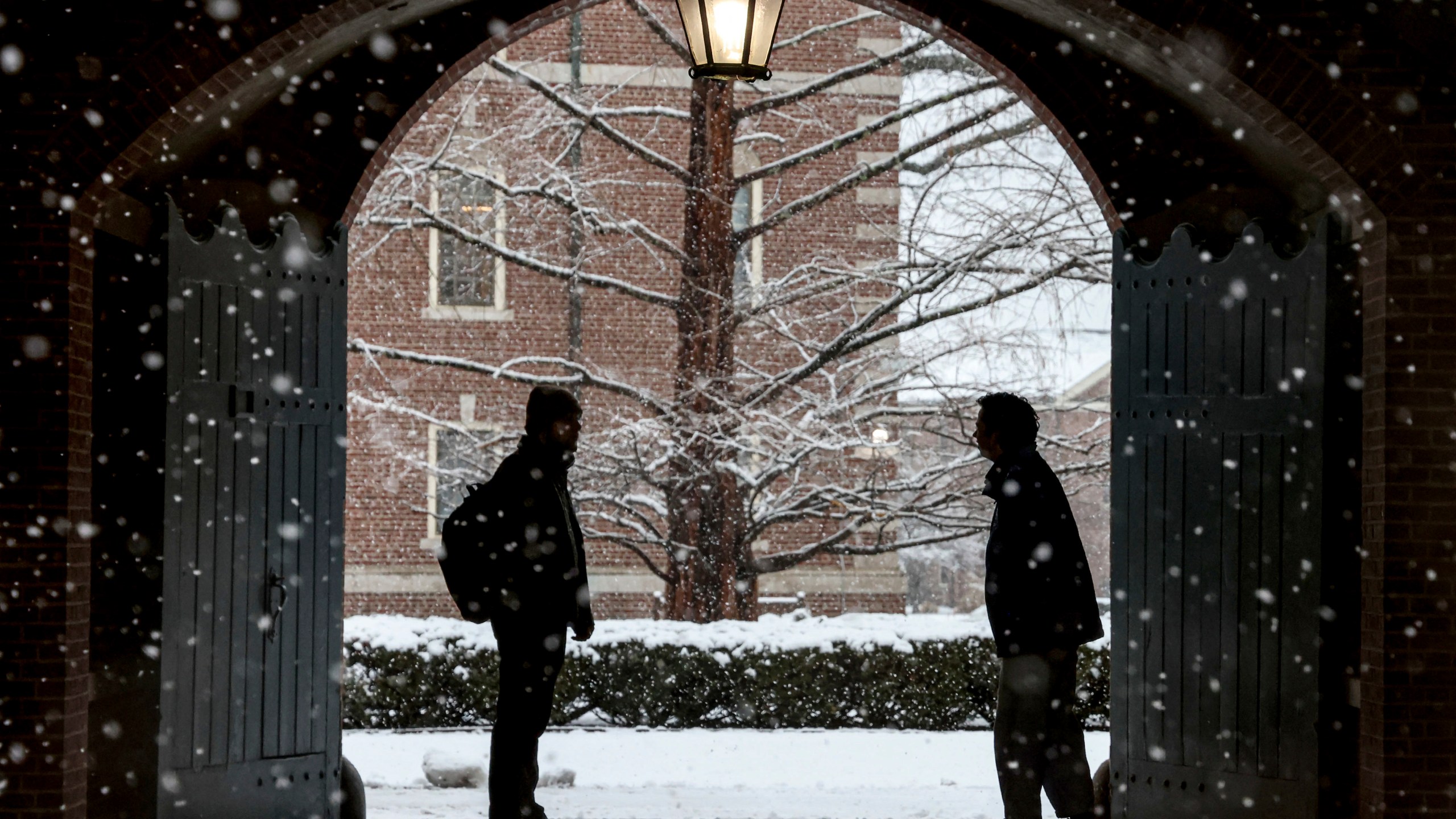 FILE - Wheaton College students stop to chat on the Norton, Mass. campus, Feb. 13, 2024 as snow falls. More than 75 million student loan borrowers have enrolled in the U.S. government's newest repayment plan since it launched in August. (Mark Stockwell/The Sun Chronicle via AP, File)