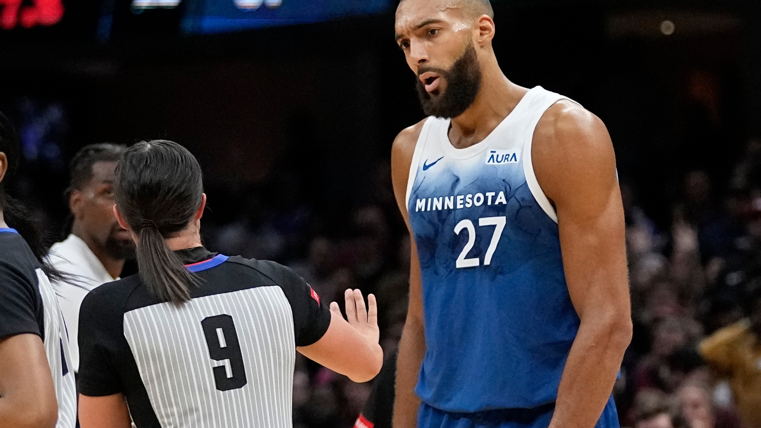 Minnesota Timberwolves center Rudy Gobert (27) talks with referee Natalie Sago (9) after being called for a technical foul in the second half of an NBA basketball game against the Cleveland Cavaliers, Friday, March 8, 2024, in Cleveland. (AP Photo/Sue Ogrocki)