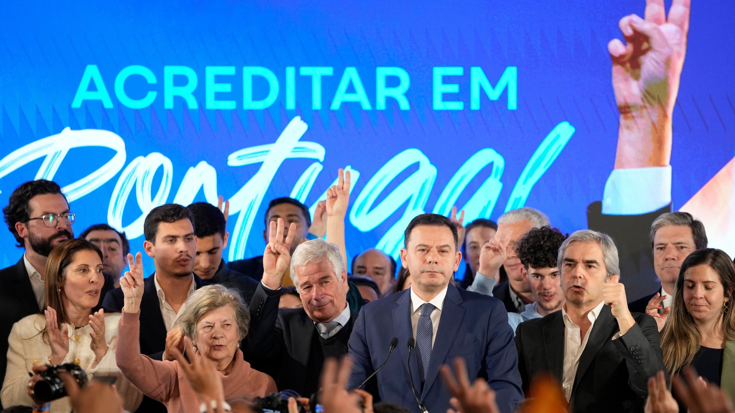 Luis Montenegro, leader of the center-right Democratic Alliance, center right, listens to his to supporters celebrating after claiming victory in Portugal's election, in Lisbon, Monday, March 11, 2024. AP Photo/Armando Franca)