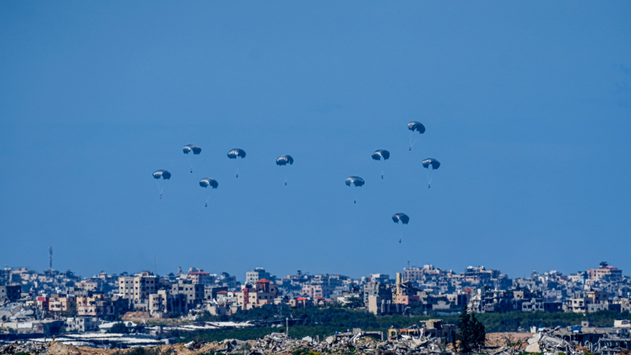 Parachutes drop supplies into the northern Gaza Strip, as seen from southern Israel , Sunday, March 10, 2024. (AP Photo/Ariel Schalit)