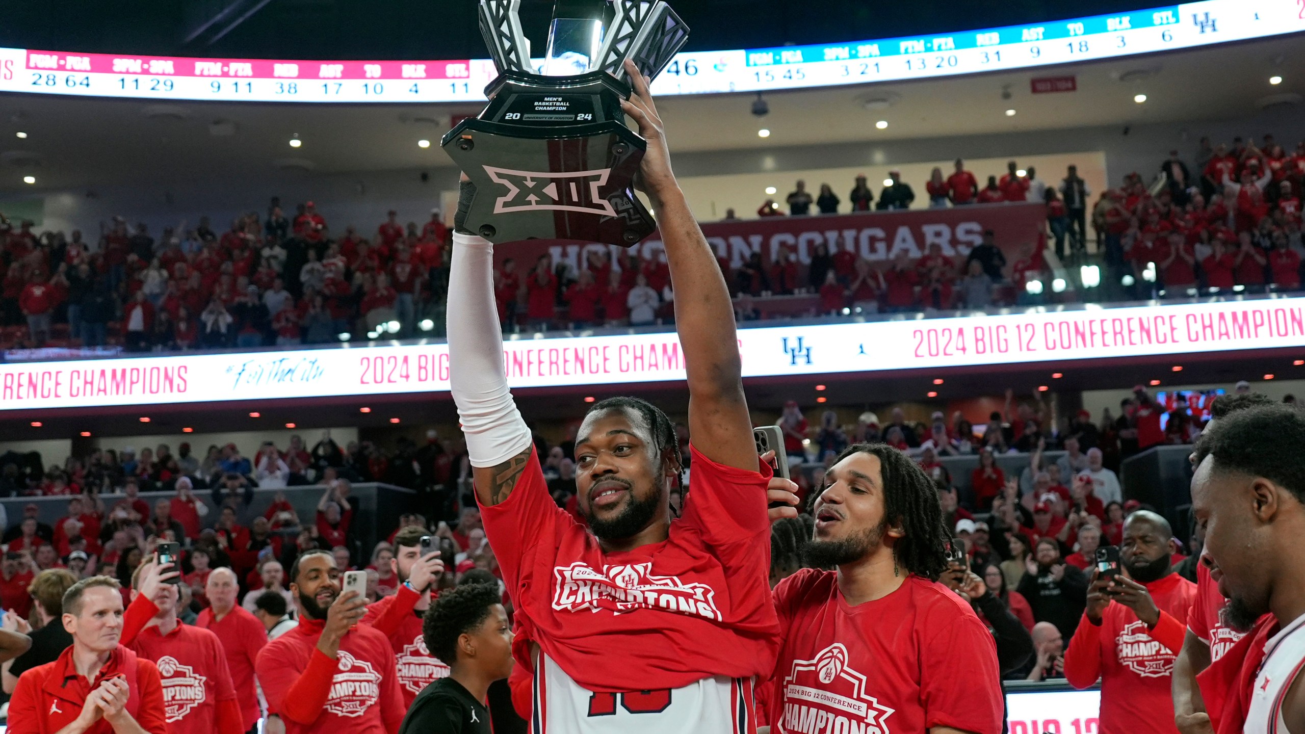 Houston's J'Wan Roberts, center, holds up the trophy after an NCAA college basketball game against Kansas Saturday, March 9, 2024, in Houston. Houston won 76-46 and finished the regular season as the Big 12 Conference Champions. (AP Photo/David J. Phillip)