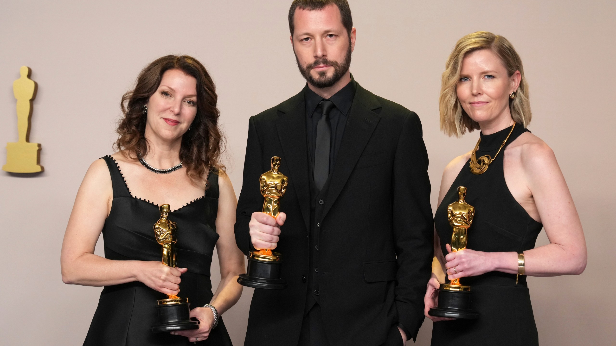 Raney Aronson-Rath, from left, Mstyslav Chernov, and Michelle Mizner pose in the press room with the award for best documentary feature film for "20 Days in Mariupol" at the Oscars on Sunday, March 10, 2024, at the Dolby Theatre in Los Angeles. (Photo by Jordan Strauss/Invision/AP)