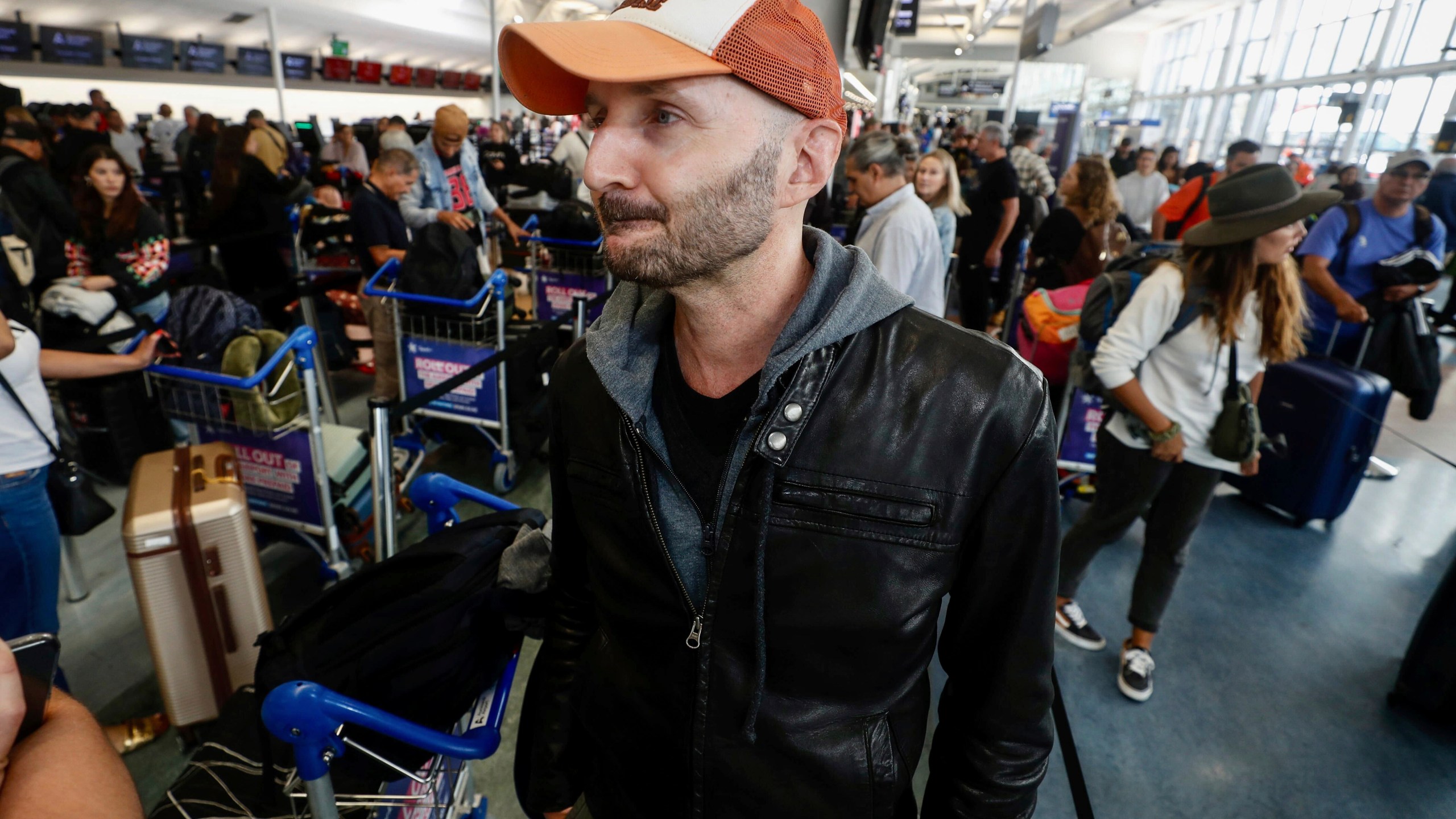 Passenger Larry Reef prepares to check in at Auckland, New Zealand airport for a LATAM Airlines flight to Santiago, Chile, Tuesday, March 12, 2024. LATAM said a flight Monday from Sydney to Auckland experienced “strong movement” that injured at least 50 people. Reef was on the flight Monday.(Dean Purcell/New Zealand Herald via AP)