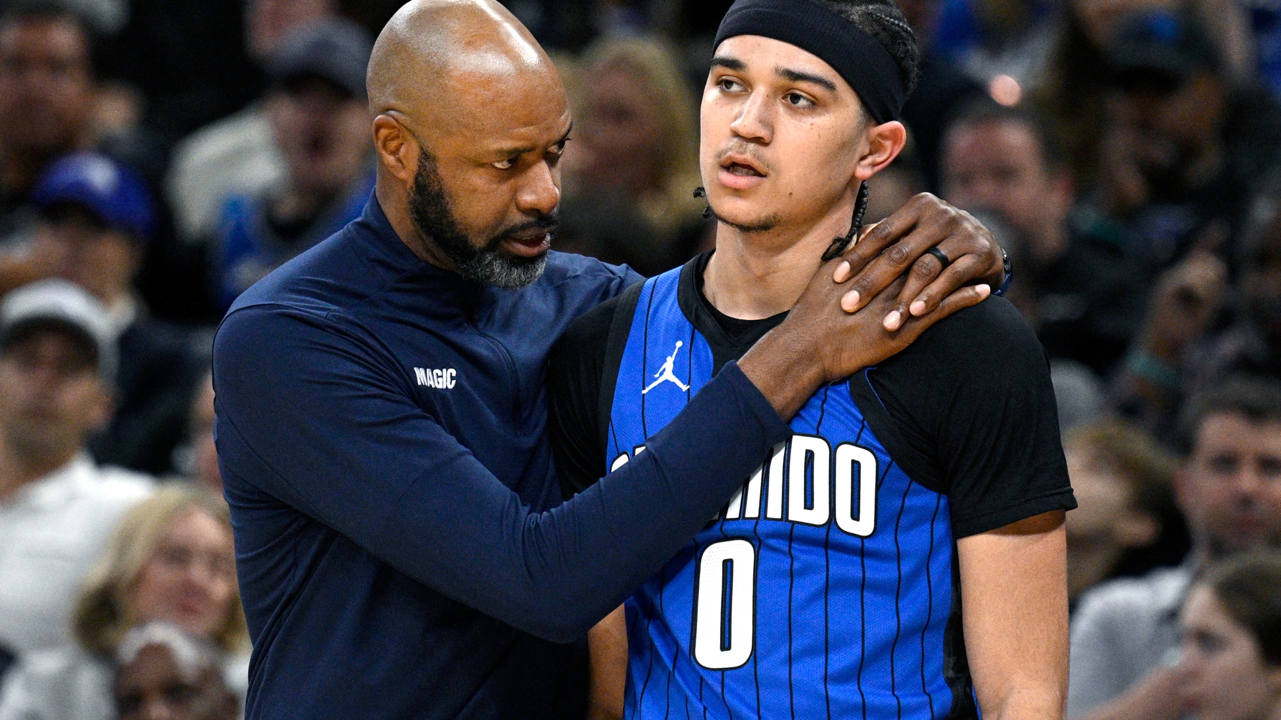 Orlando Magic head coach Jamahl Mosley, left, talks to guard Anthony Black (0) during the first half of an NBA basketball game against the Indiana Pacers, Sunday, March 10, 2024, in Orlando, Fla. (AP Photo/Phelan M. Ebenhack)