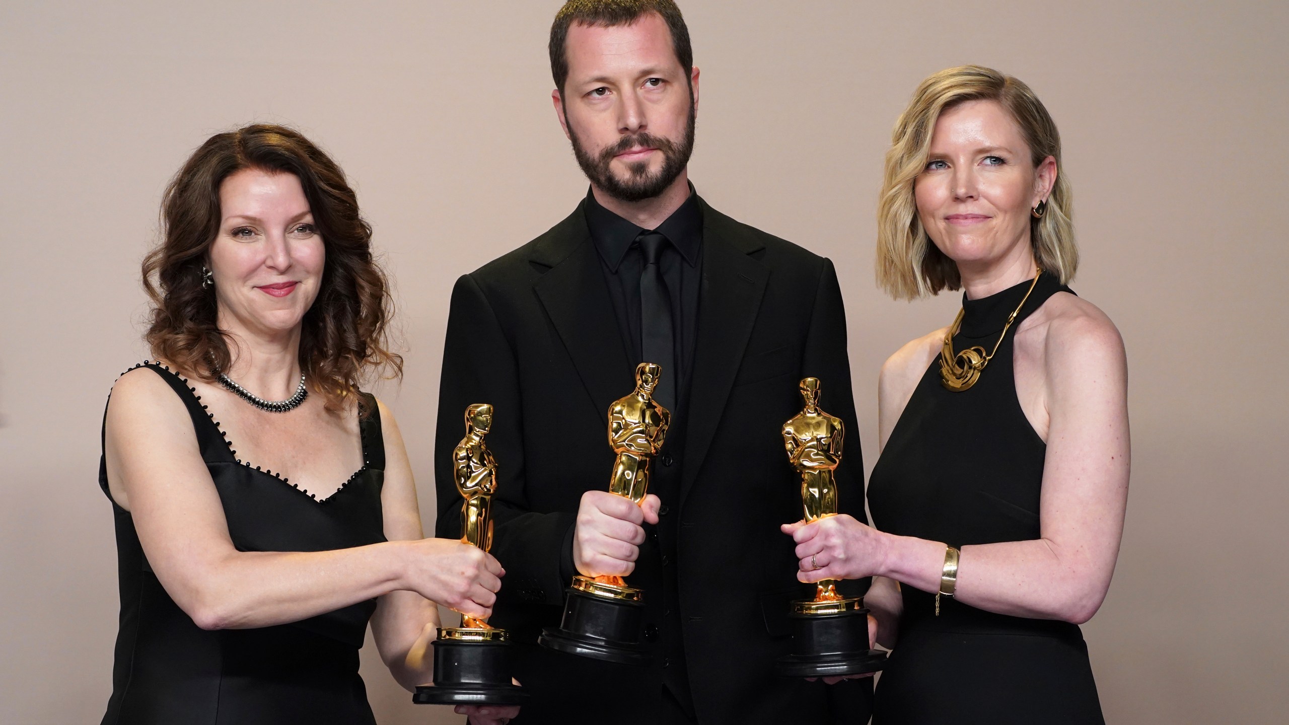 Raney Aronson-Rath, from left, Mstyslav Chernov, and Michelle Mizner pose in the press room with the award for best documentary feature film for "20 Days in Mariupol" at the Oscars on Sunday, March 10, 2024, at the Dolby Theatre in Los Angeles. (Photo by Jordan Strauss/Invision/AP)