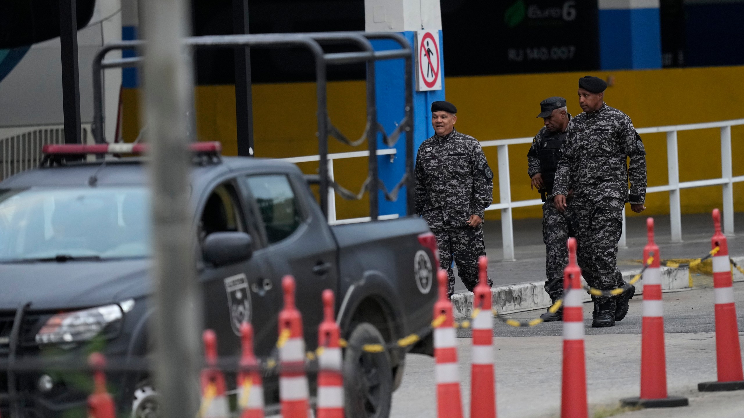 Elite police walk through a bus terminal where police say a gunman wounded two people and took 17 others hostage aboard a bus, in Rio de Janeiro, Brazil, Tuesday, March 12, 2024. (AP Photo/Silvia Izquierdo)