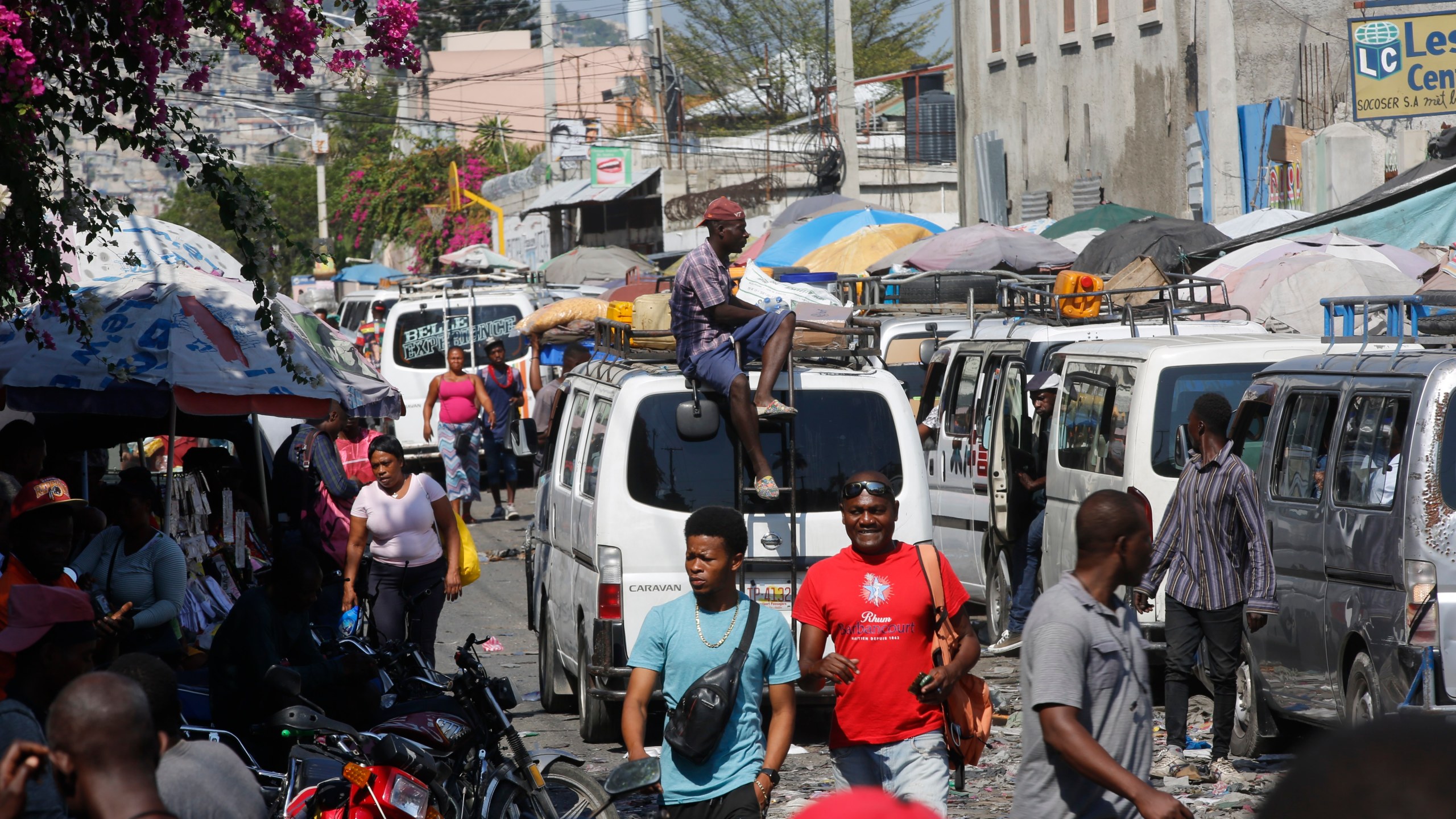 Pedestrians and commuters fill a street in Port-au-Prince, Haiti, Tuesday, March 12, 2024. Haitian Prime Minister Ariel Henry announced Tuesday that he would resign once a transitional presidential council is created, bowing to international pressure to make way for new leadership in the country overwhelmed by violent gangs. (AP Photo/Odelyn Joseph)