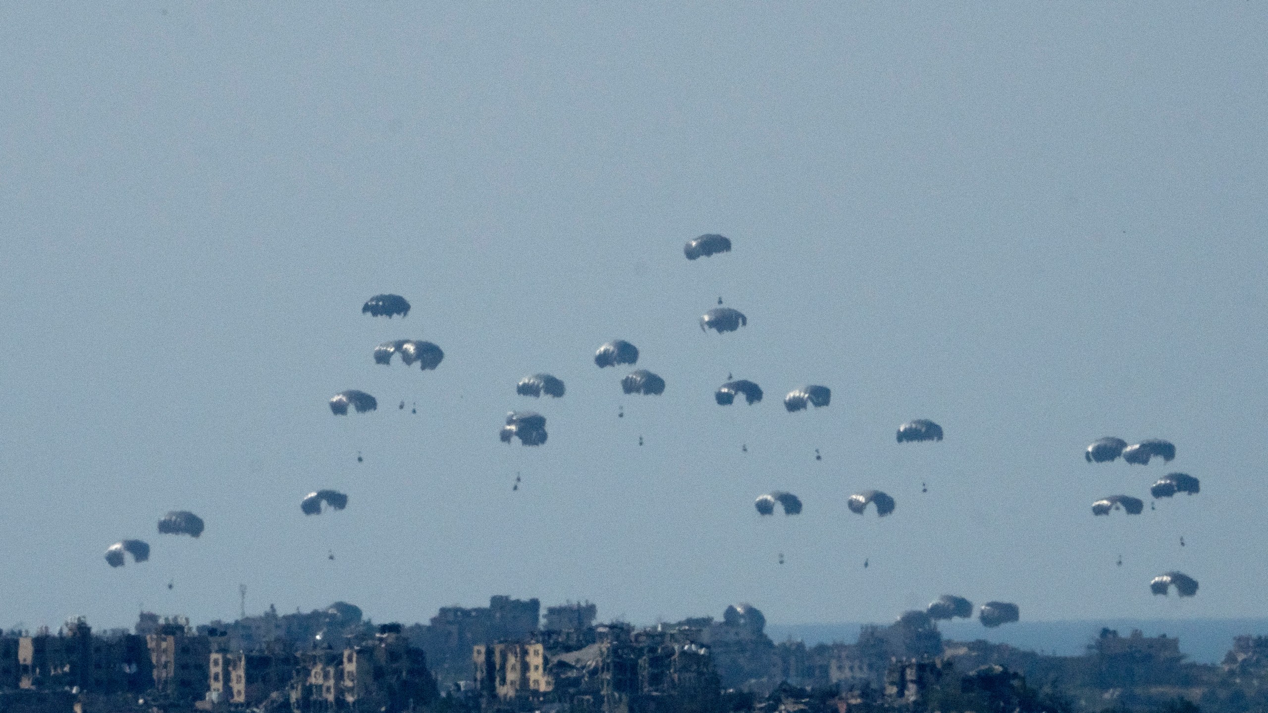 Parachutes drop humanitarian aid into the northern Gaza Strip, as seen from southern Israel, Monday, March 11, 2024. (AP Photo/Maya Alleruzzo)