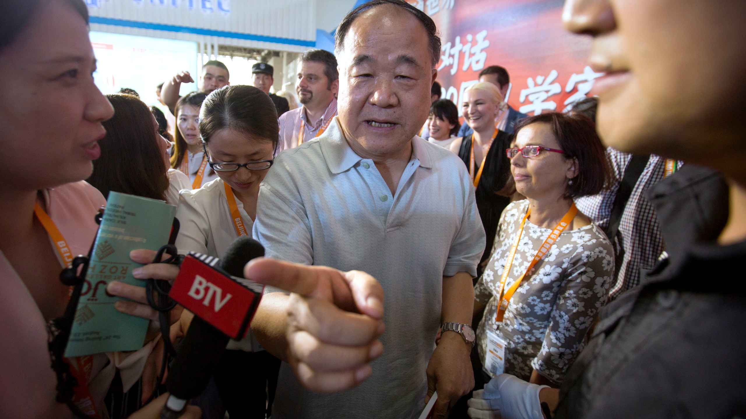 FILE - Chinese Literature Nobel Prize winner Mo Yan, center, leaves following a panel discussion at the Beijing International Book Fair in Beijing, Wednesday, Aug. 23, 2017. Mo Yan, one of China's most celebrated authors, who won the country's first Nobel Prize for literature and was once praised by top officials, is now at a center of a nationalist storm, indicating the shifting lines for freedom of expression under Chinese President Xi Jinping. (AP Photo/Mark Schiefelbein, File)