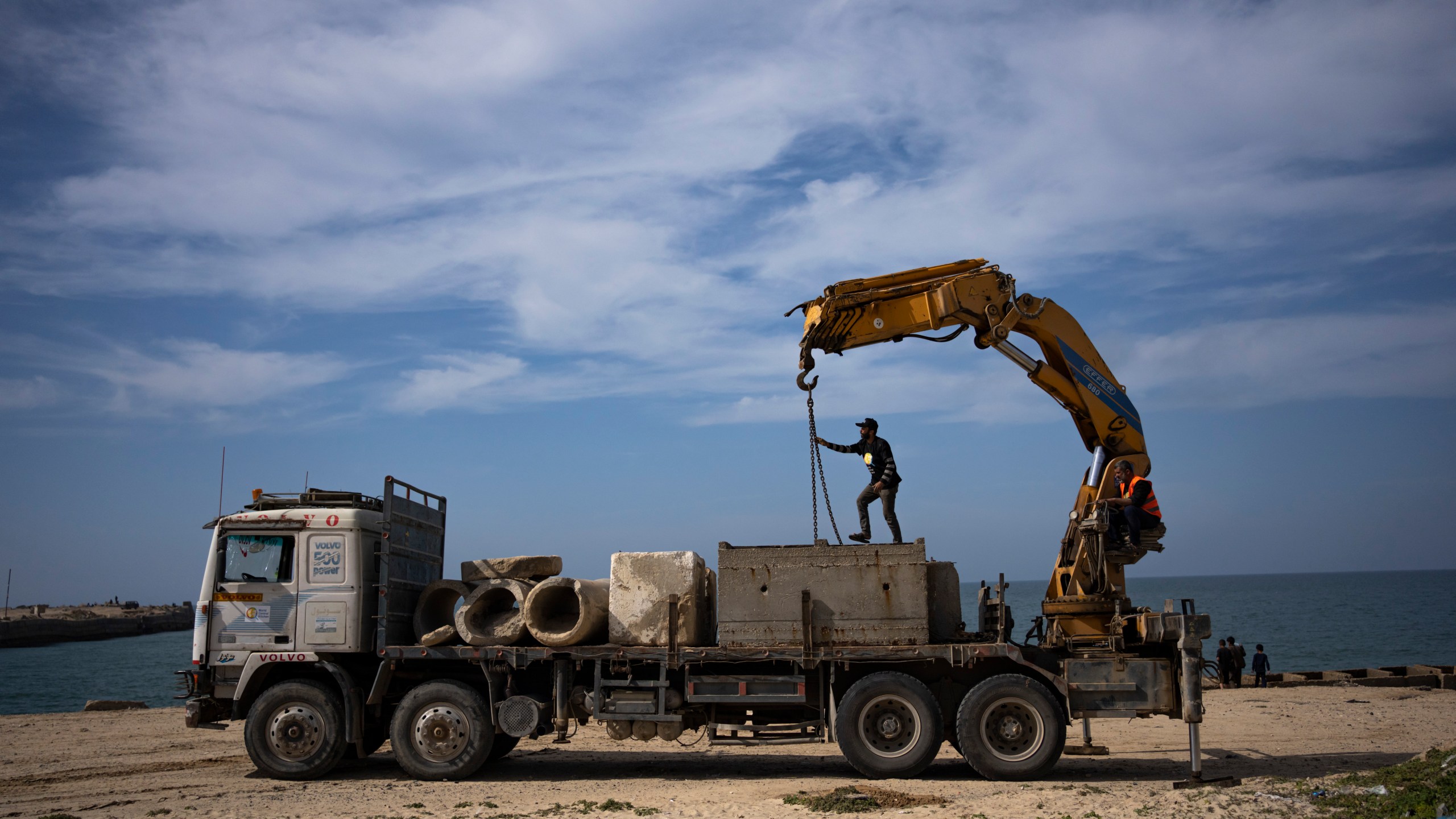Palestinians bring cement blocks to a pier that could be used to bring humanitarian aid to the Gaza Strip in Khan Younis on Wednesday, March 13, 2024. (AP Photo/Fatima Shbair)