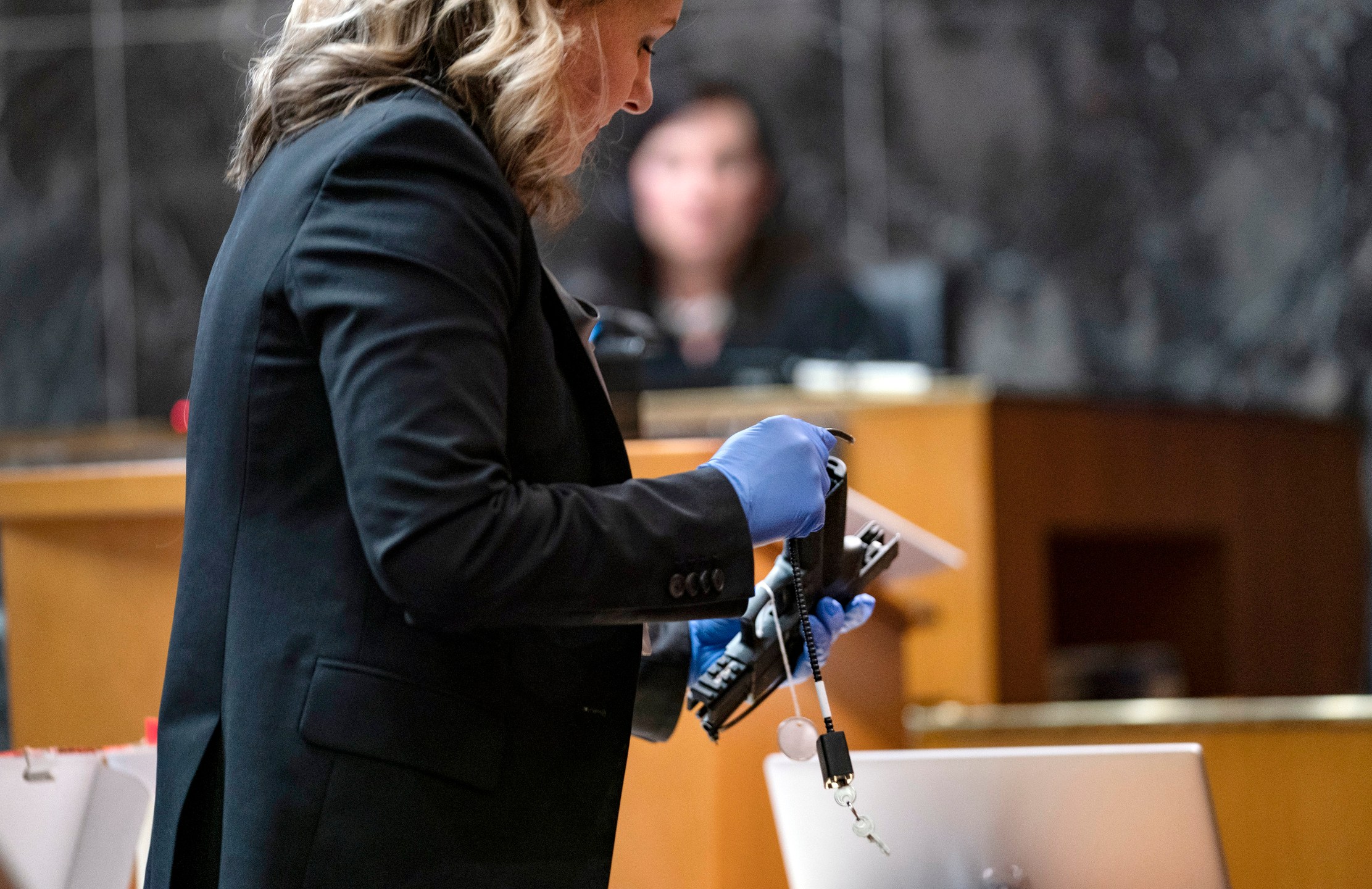 Oakland County Prosecutor Karen McDonald demonstrates how swiftly she was able to insert a gun lock during closing statements in the trial of James Crumbley, Wednesday, March, 13, 2024 in Pontiac, Mich. Crumbley is charged with involuntary manslaughter, accused of failing to secure a gun at home and ignoring his son's mental health. Ethan Crumbley killed four students at Oxford High School in 2021. (Mandi Wright/Detroit Free Press via AP, Pool)