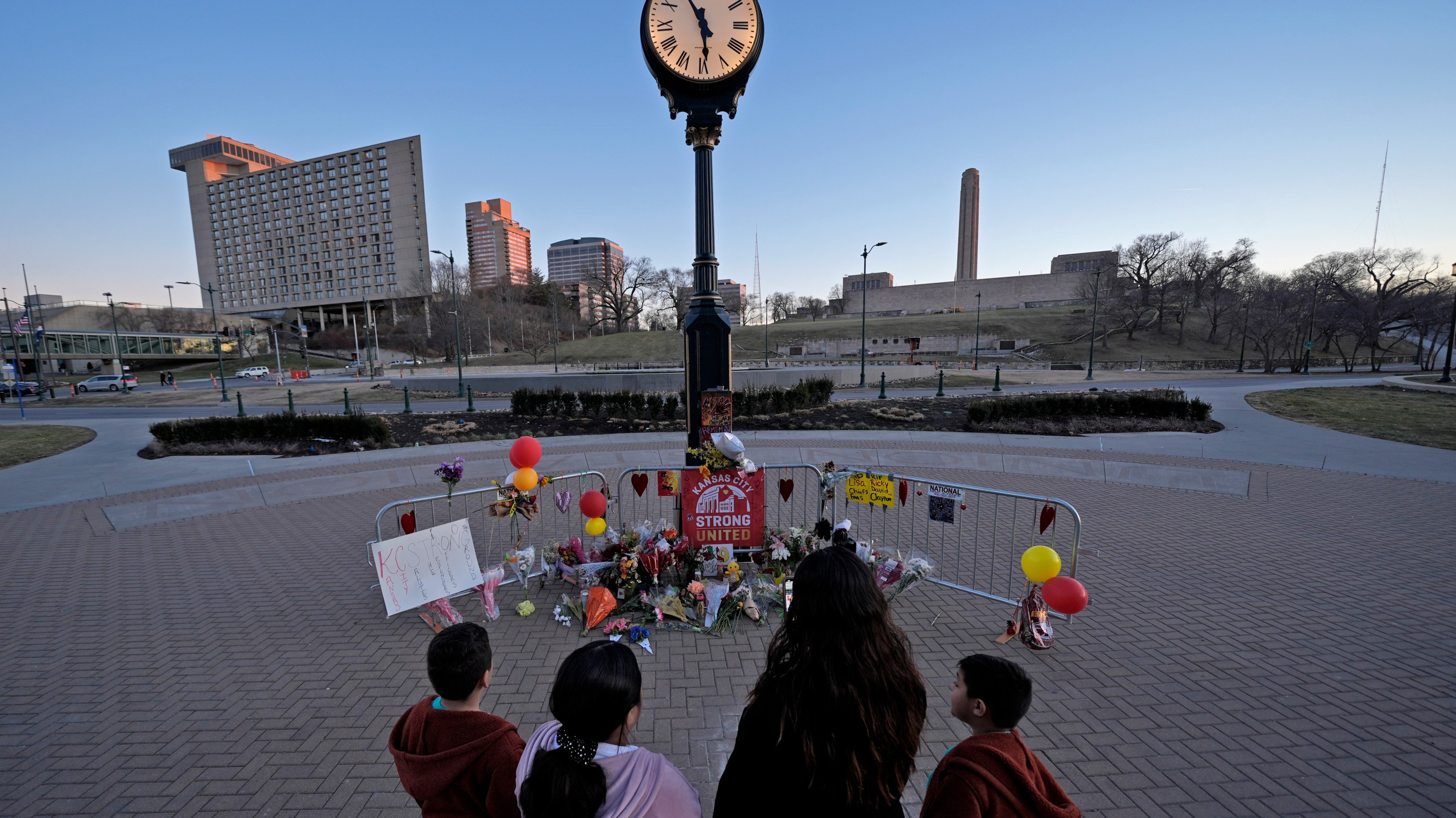 FILE - People view a memorial, Sunday, Feb. 18, 2024, in Kansas City, Mo., dedicated to the victims of a shooting at the Kansas City Chiefs NFL football Super Bowl celebration. Three men from Kansas City, Mo.,, face firearms charges, including gun trafficking, after an investigation into the mass shooting during the Kansas City Chiefs’ Super Bowl parade and rally, federal prosecutors said Wednesday, March 13, 2024. (AP Photo/Charlie Riedel, File)