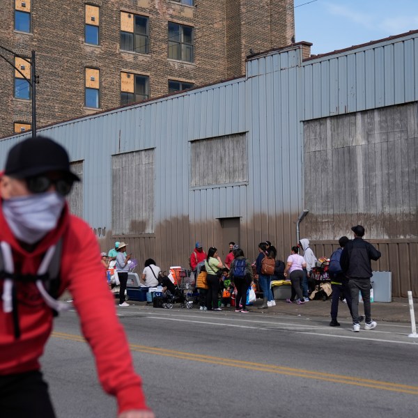 People hang around outside of a migrant shelter Wednesday, March 13, 2024, in the Pilsen neighborhood of Chicago.