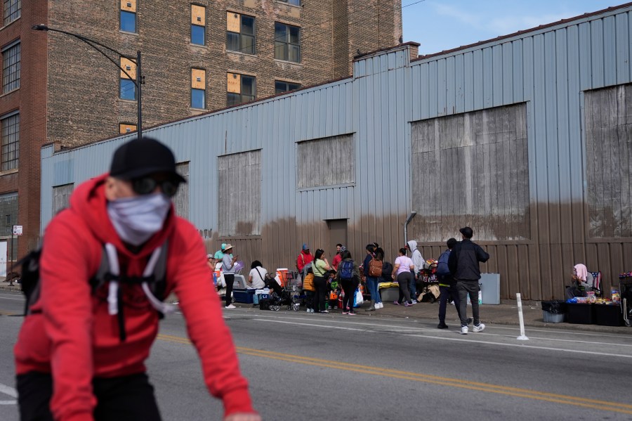 People hang around outside of a migrant shelter Wednesday, March 13, 2024, in the Pilsen neighborhood of Chicago.