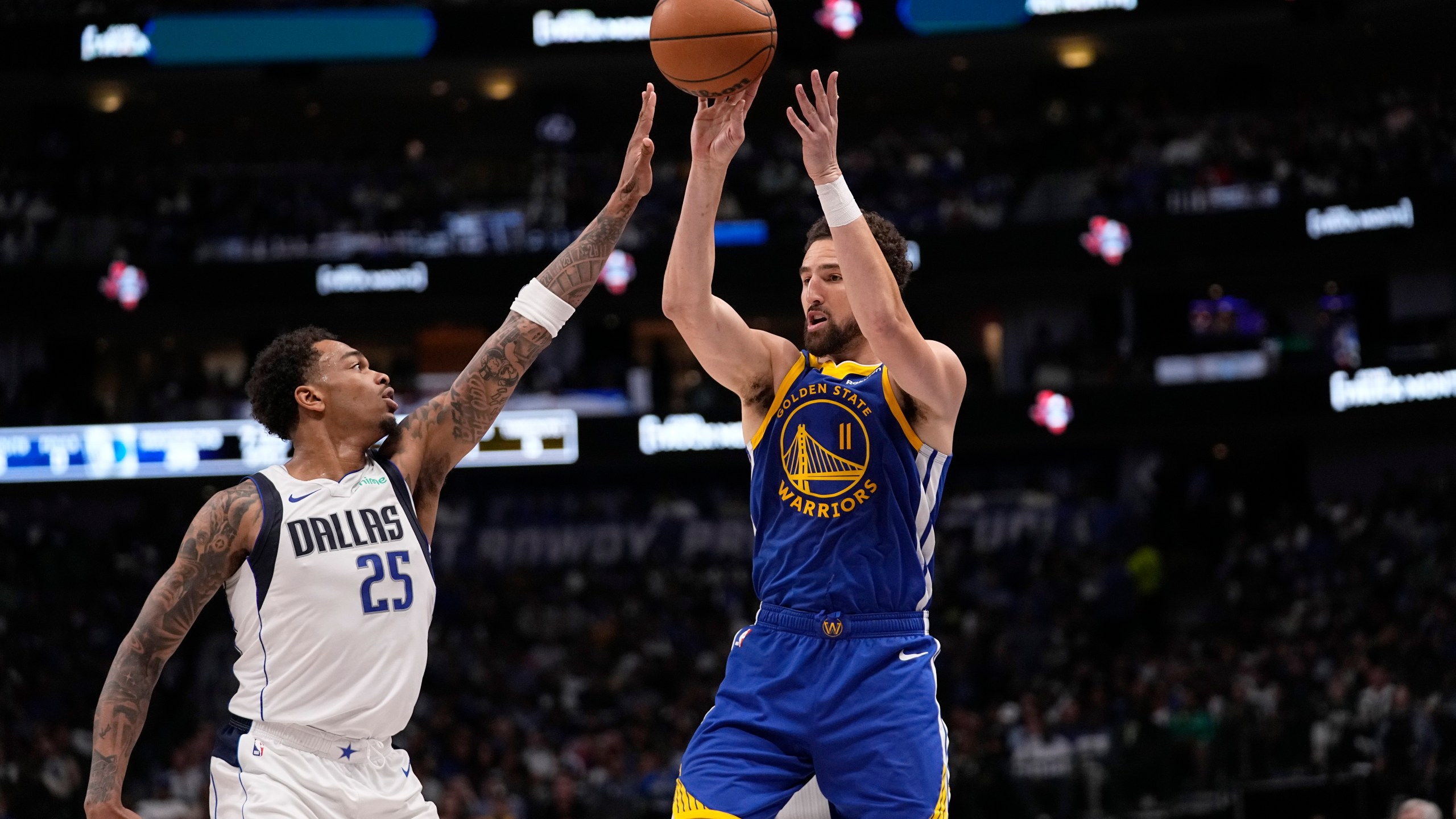 Golden State Warriors guard Klay Thompson (11) passes the ball as Dallas Mavericks forward P.J. Washington (25) defends during the first half of an NBA basketball game in Dallas, Wednesday, March 13, 2024. (AP Photo/Tony Gutierrez)