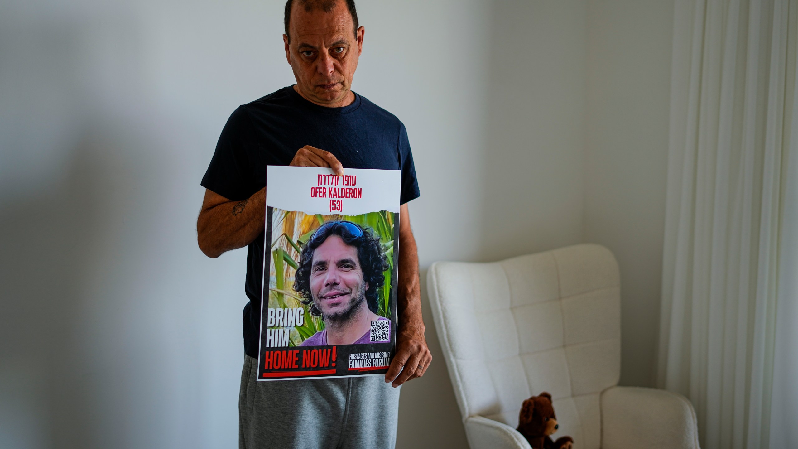 Nissan Kalderon poses with a photo of his only brother, Ofer, a hostage held in the Gaza Strip by the Hamas militant group, in Ramat Gan, Israel, Wednesday, March 13, 2024. With each passing day, the relatives of hostages in Gaza face a deepening despair. (AP Photo/Ariel Schalit)