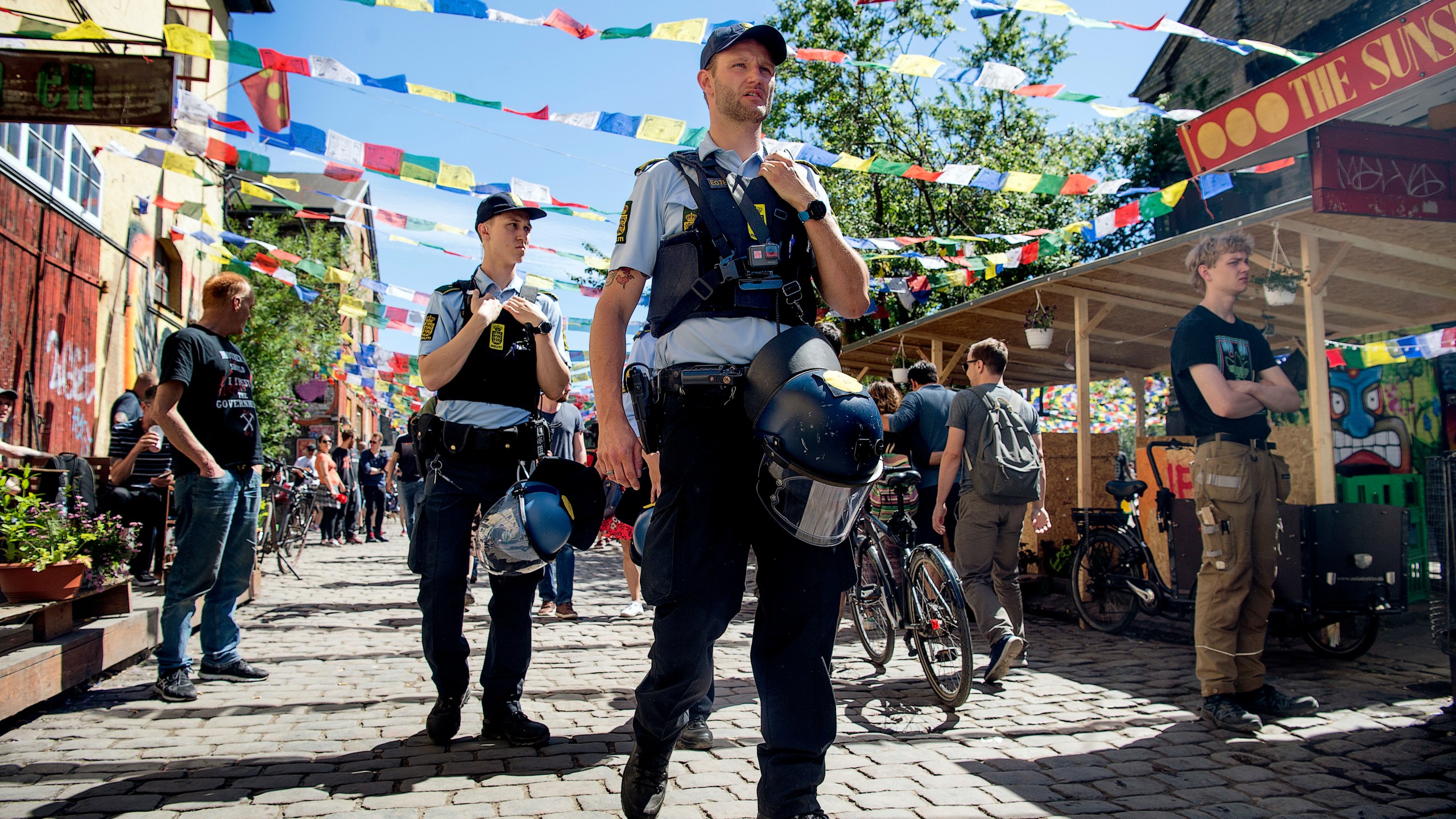 FILE - Police patrol Pusher Street in at Christiania, Copenhagen, Friday, May 25, 2018, after the street reopened after having been closed for three days. The inhabitants of Copenhagen's freewheeling Christiania neighborhood want dig up the aptly named Pusher Street where cannabis has been sold for decades although the trade is illegal, in the latest attempt to stop the hashish sale which has led to deadly gang turf wars and sometimes violent confrontations with the police. (Nils Meilvang/Ritzau Scanpix via AP, File)
