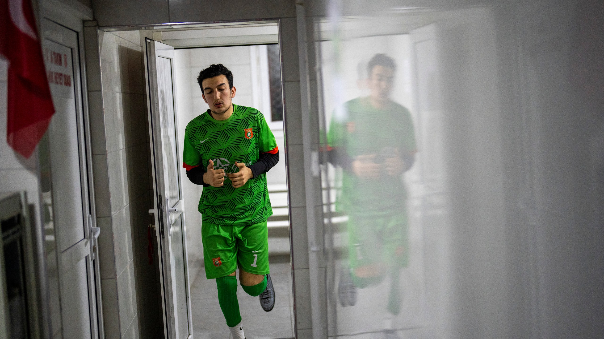 Amateur goalkeeper Mustafa Mert Olcer leaves the locker room before playing a recreational soccer "Astroturf" match in Istanbul, Turkey, Tuesday, March 5, 2024. More than a few times a week, the 18-year-old courier and passionate goalkeeper Mustafa Mert Olcer, gets a call from Rent-a-Goalkeeper to man a goalpost. (AP Photo/Francisco Seco)