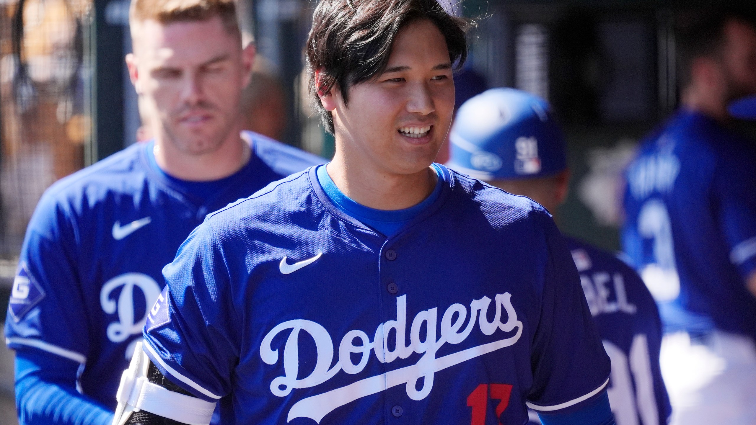 FILE - Los Angeles Dodgers' Shohei Ohtani, of Japan, walks through the dugout during the team's spring training baseball game against the Seattle Mariner, March 13, 2024, in Phoenix. Beginning with its ninth international opener, Major League Baseball is traveling all over the world in 2024. Ohtani and the Dodgers play Manny Machado and the San Diego Padres in Seoul, South Korea (AP Photo/Ross D. Franklin, File)