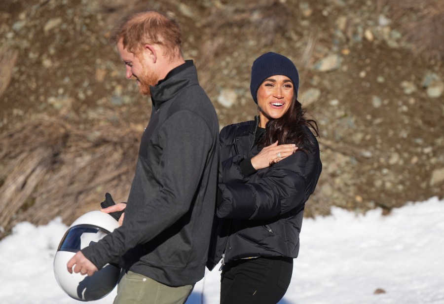 Prince Harry and Meghan Markle, the Duke and Duchess of Sussex, walk together after Harry slid down the track on a skeleton sled a second time while attending an Invictus Games training camp, in Whistler, British Columbia. Thursday, Feb. 15, 2024. (Darryl Dyck/The Canadian Press via AP)