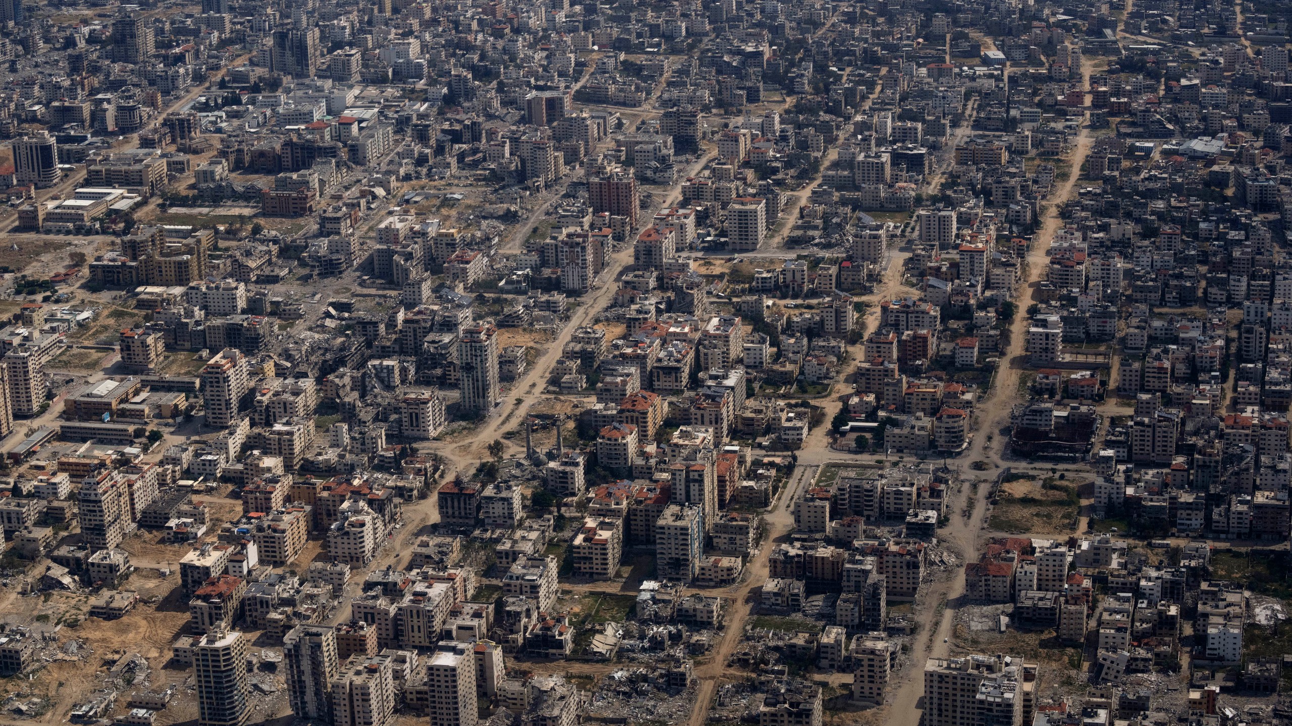 Destroyed buildings are seen through the window of an airplane from the U.S. Air Force overflying the Gaza Strip, Thursday, March 14, 2024. (AP Photo/Leo Correa)