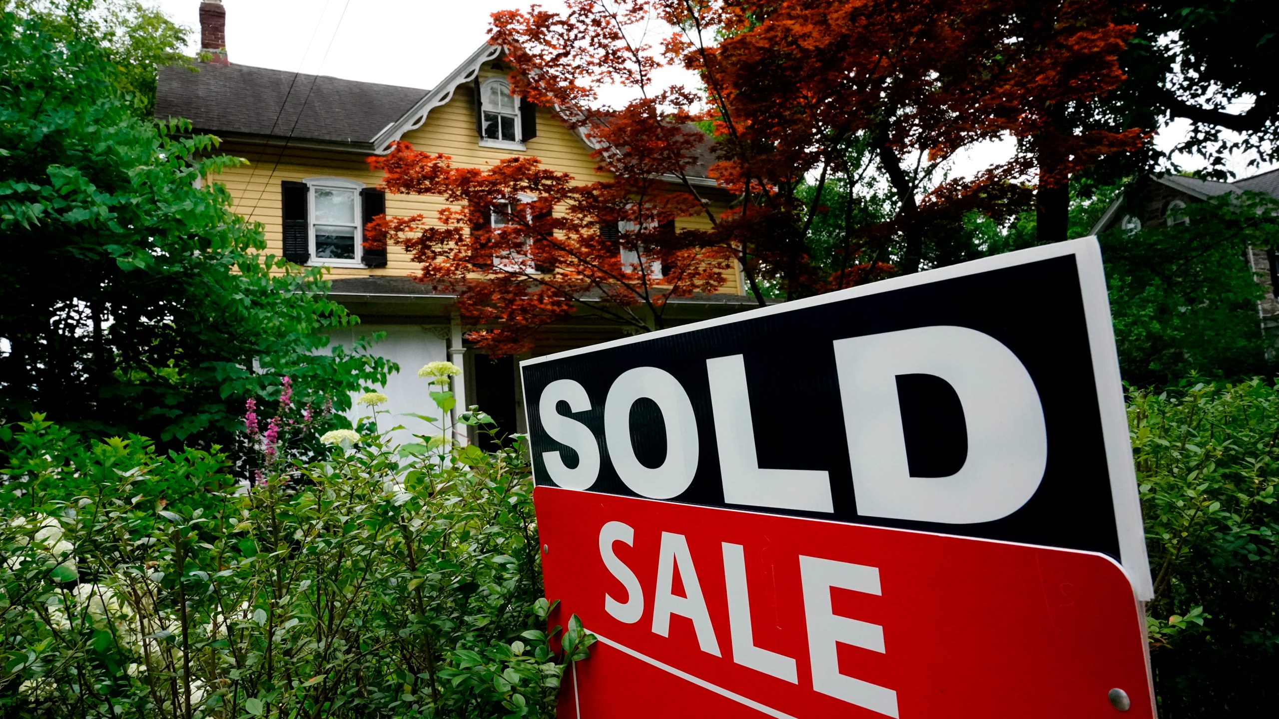 FILE - A sale sign stands outside a home in Wyndmoor, Pa., Wednesday, June 22, 2022. The National Association of Realtors has agreed on Friday, March 15, 2024, to pay $418 million and change its rules to settle lawsuits claiming homeowners have been unfairly forced to pay artificially inflated agent commissions when they sold their home. (AP Photo/Matt Rourke, File)