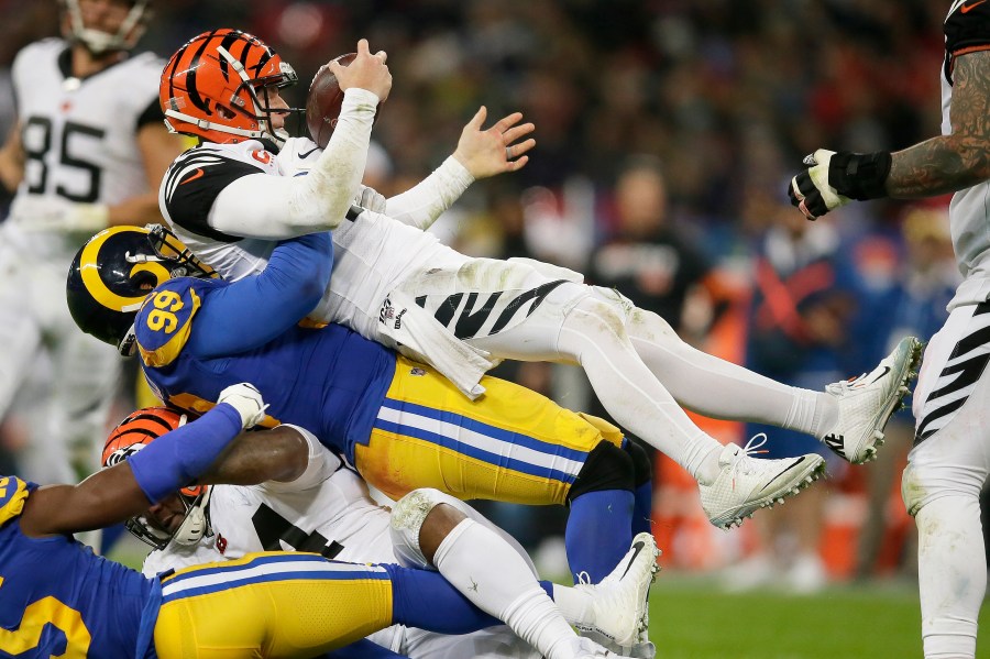 FILE - Cincinnati Bengals quarterback Andy Dalton, top, is sacked by Los Angeles Rams defensive tackle Aaron Donald during the second half of an NFL football game, Sunday, Oct. 27, 2019, at Wembley Stadium in London. Defensive lineman Aaron Donald has announced his retirement after a standout 10-year career with the Los Angeles Rams. The three-time AP NFL Defensive Player of the Year made his surprising announcement on social media Friday, March 15, 2024. (AP Photo/Tim Ireland, File)