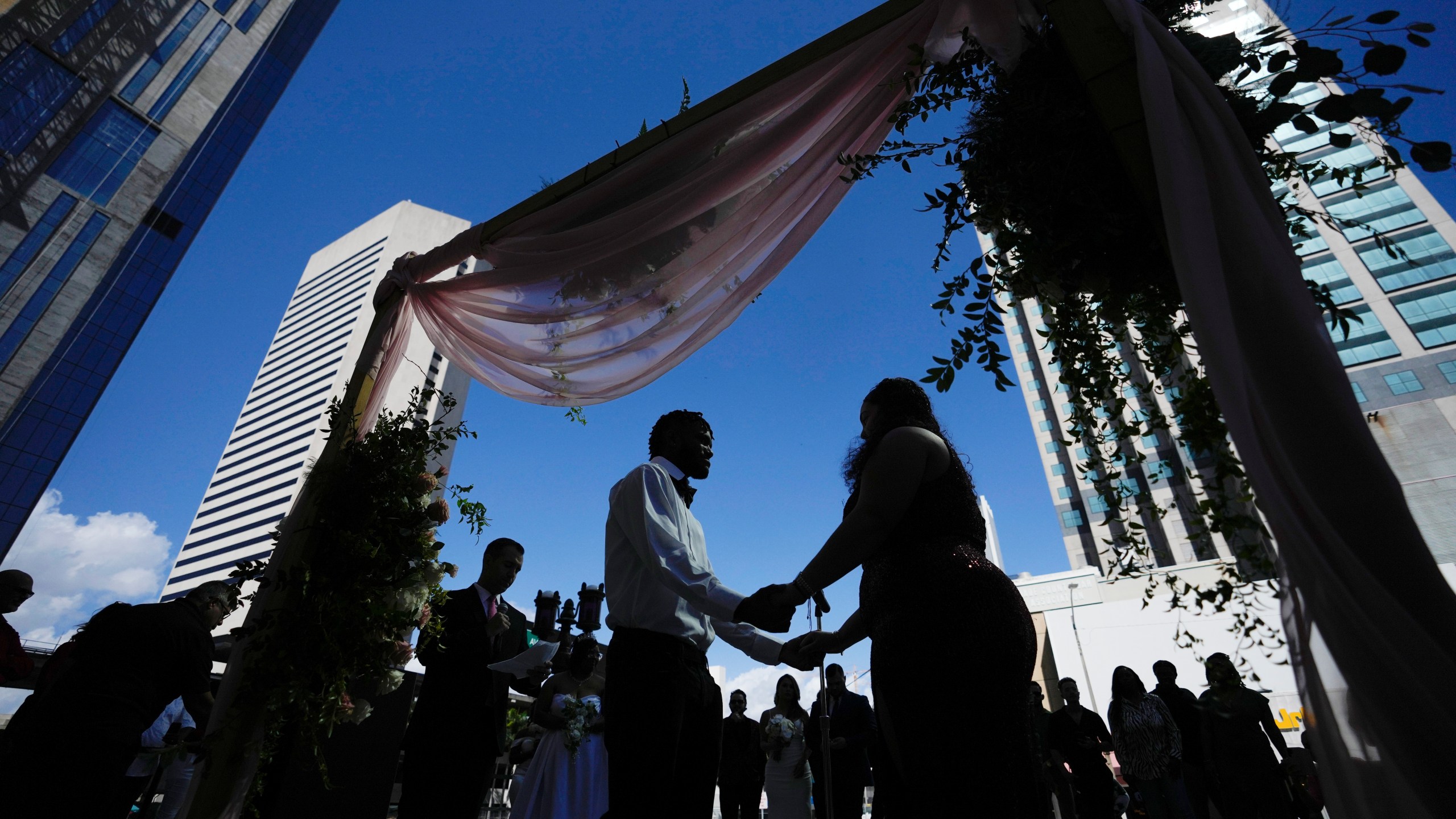 FILE - A couple holds hands as they are married by a county clerk during a Valentine's Day group wedding ceremony on the steps of the Dade County Courthouse in Miami, Wednesday, Feb. 14, 2024. U.S. marriages have rebounded to pre-pandemic levels with nearly 2.1 million in 2022, a 4% increase from the year before, the Centers for Disease Control and Prevention said in a report published Friday, March 15, 2024. (AP Photo/Rebecca Blackwell, File)
