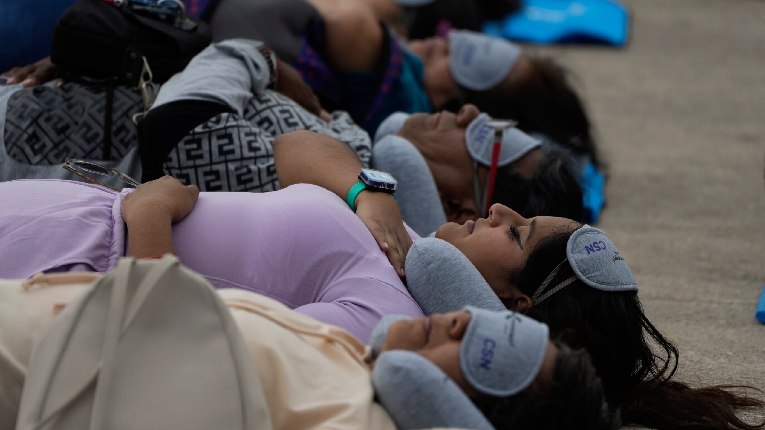 Equipped with mats, sleeping masks and travel pillows, people lie sprawled out at the base of the iconic Monument to the Revolution to take a nap, in Mexico City, Friday, March 15, 2024. Dubbed the “mass siesta,” the event was in commemoration of World Sleep Day. (AP Photo/Fernando Llano)