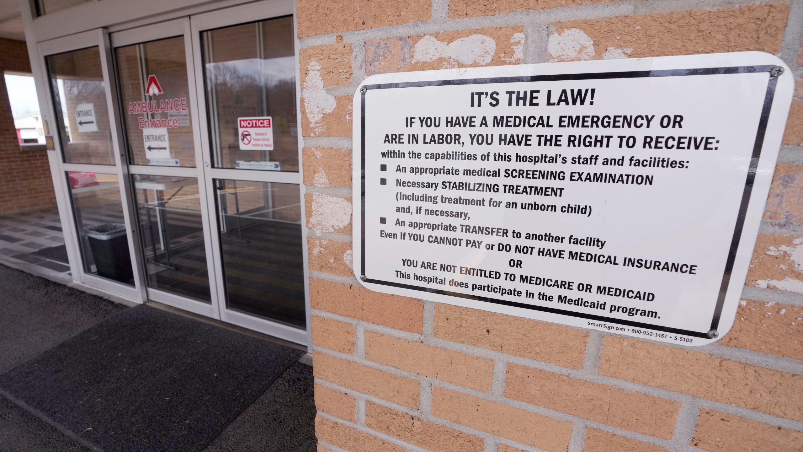 A sign spells out the rights a medical emergency patient has at the emergency room entrance outside the Alliance Healthcare System hospital in Holly Springs, Miss., Feb. 29, 2024. (AP Photo/Rogelio V. Solis)