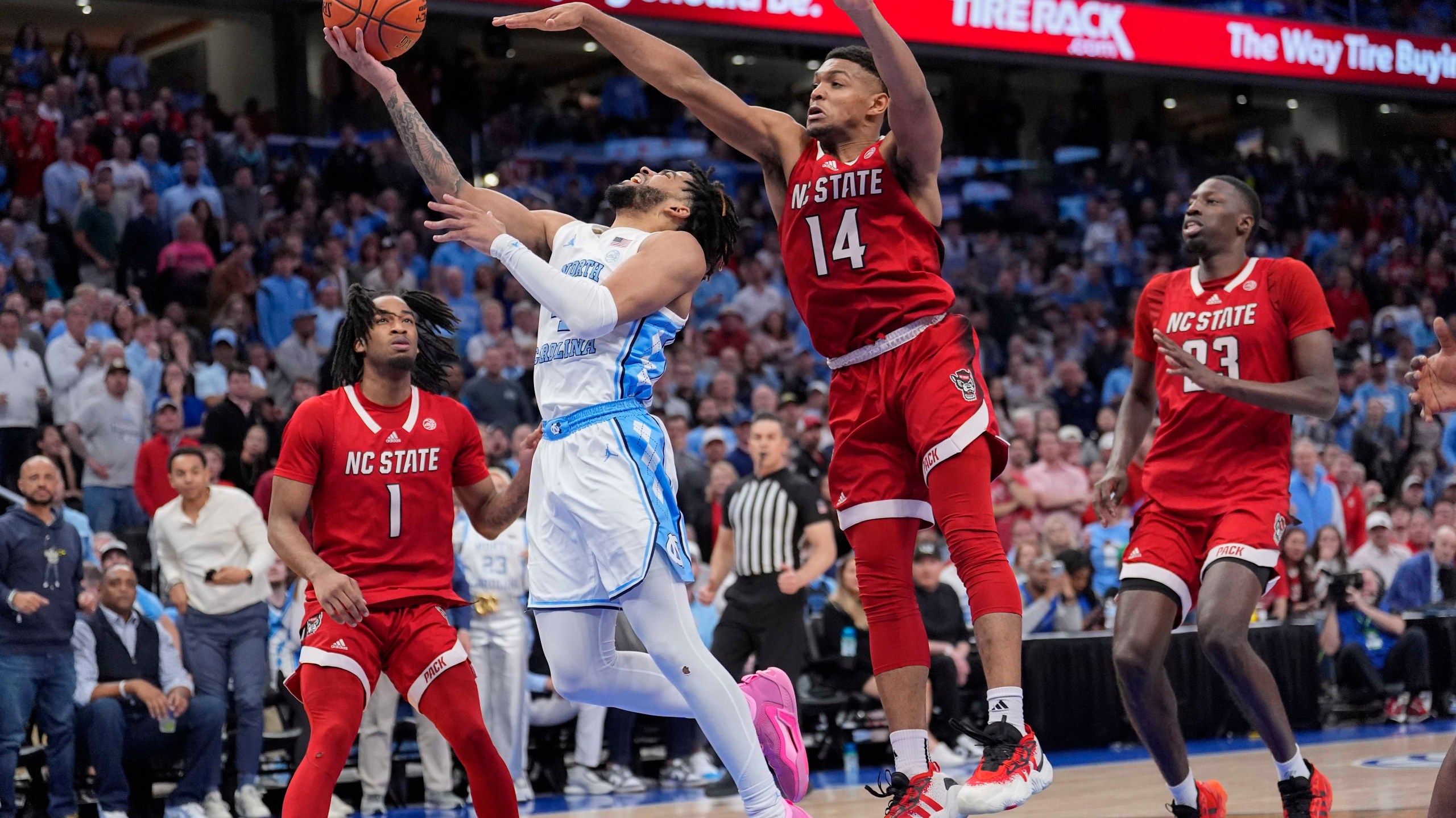 North Carolina guard RJ Davis (4) shots against North Carolina State guard Casey Morsell (14) during the second half of an NCAA college basketball game in the championship of the Atlantic Coast Conference tournament, Saturday, March 16, 2024, in Washington. (AP Photo/Alex Brandon)