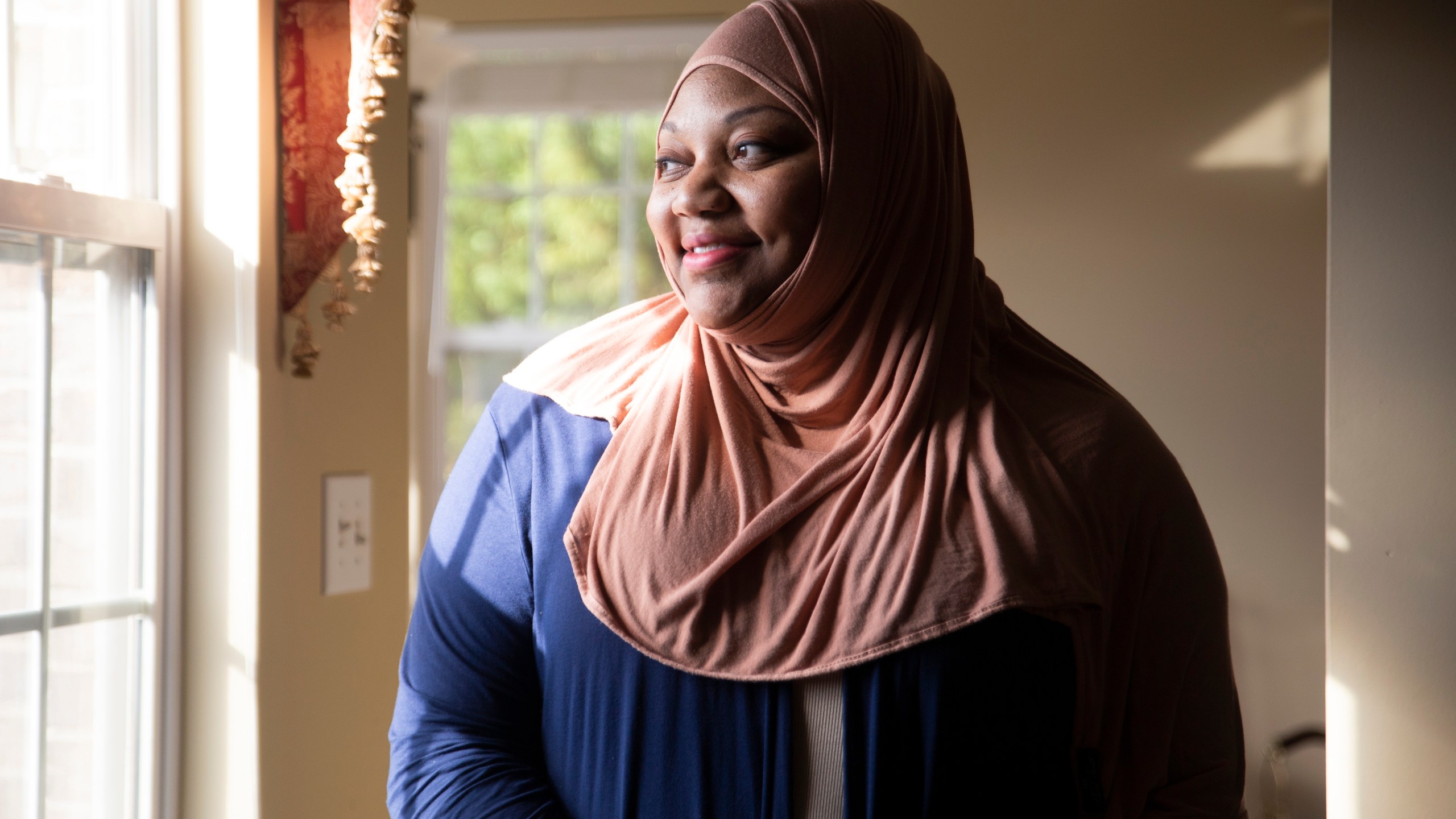 Imani Mfalme poses for a portrait inside her late mother's house Thursday, March 7, 2024, in Knoxville, Tenn. Mfalme's mother suffered from Alzheimer's and was placed in long term care. After her death the state is now trying to lay claim to the estate to pay for that care. (AP Photo/Caitie McMekin)